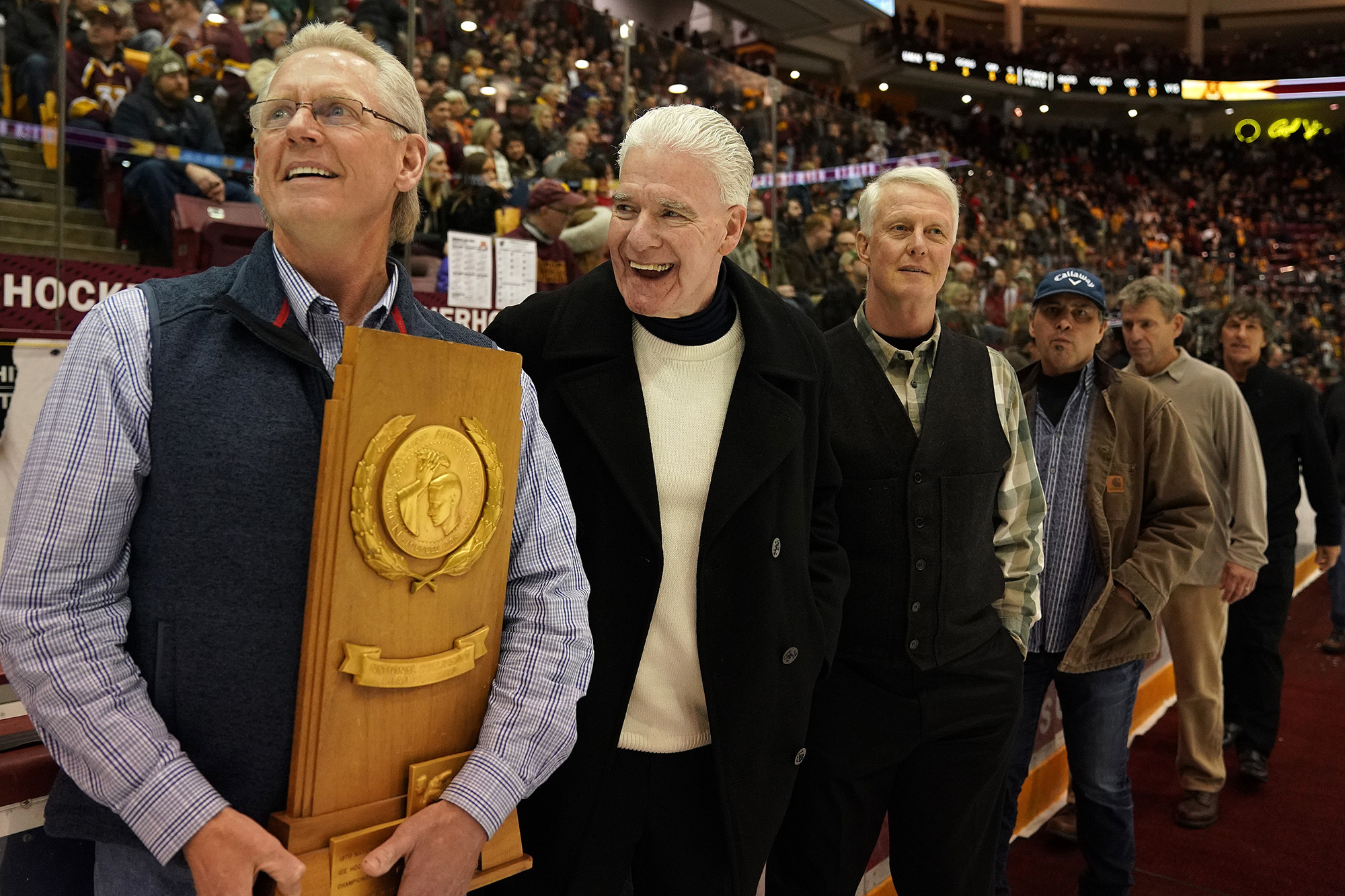 Bill Baker, left, captain of the 1979 Gophers men's hockey team, laughs along with teammates honored on the ice Saturday