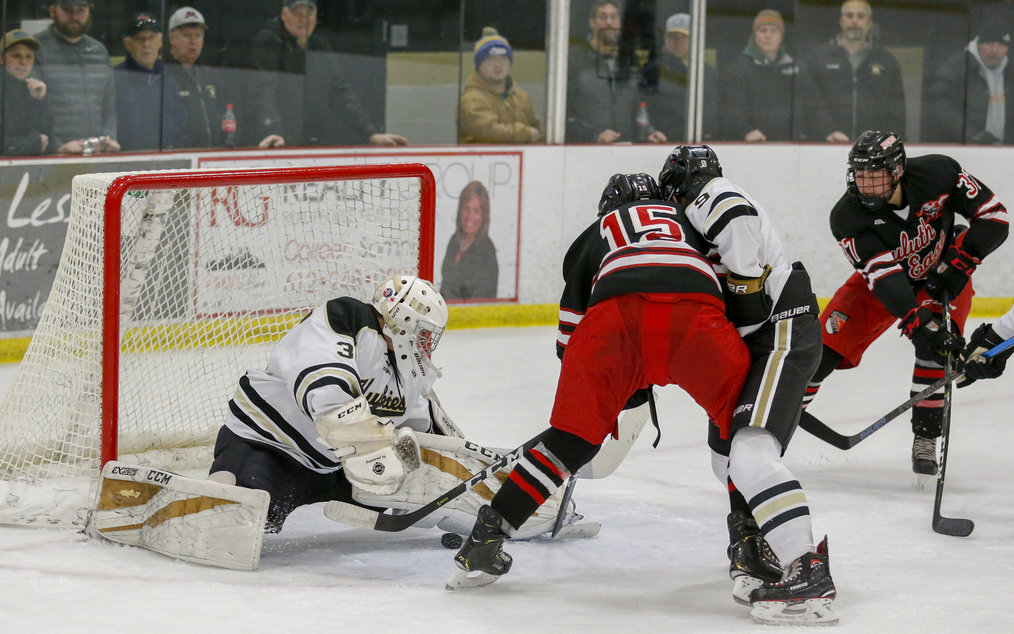 Andover's Ben Fritsinger stretches to make a second period save against Duluth East. Fritsinger had 35 saves in the Huskies' 2-1 overtime victory over