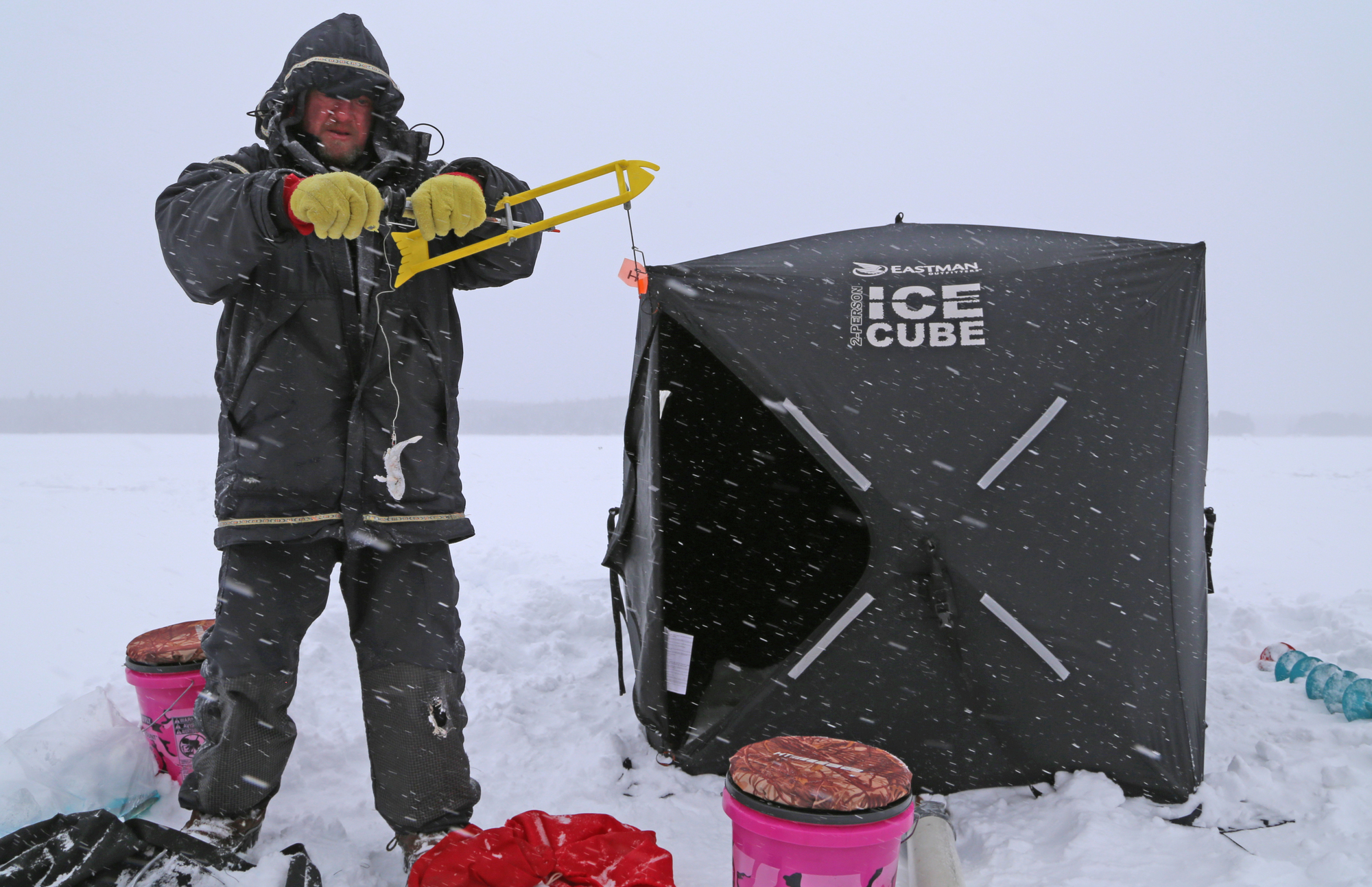 Amid heavy snow and strong winds, Stu McEntyre of Ely prepares a tip-up while fishing for northern pike in the Boundalry Waters Canoe Area Wilderness.