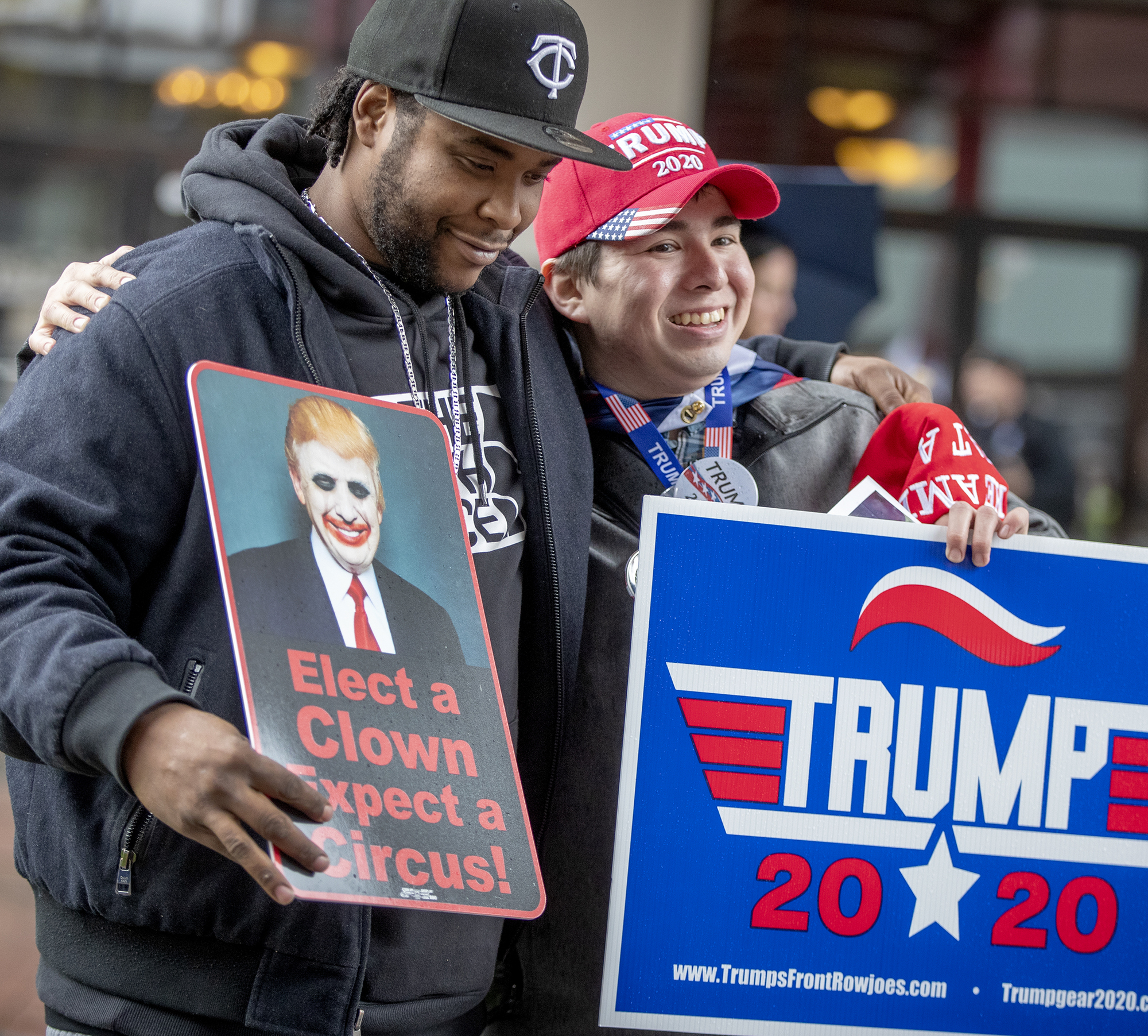 Trump protester Willy Jenkins, left, and Trump supporter Chris Windego hugged Thursday as they waited outside Target Center before President Donald Trump's campaign rally.