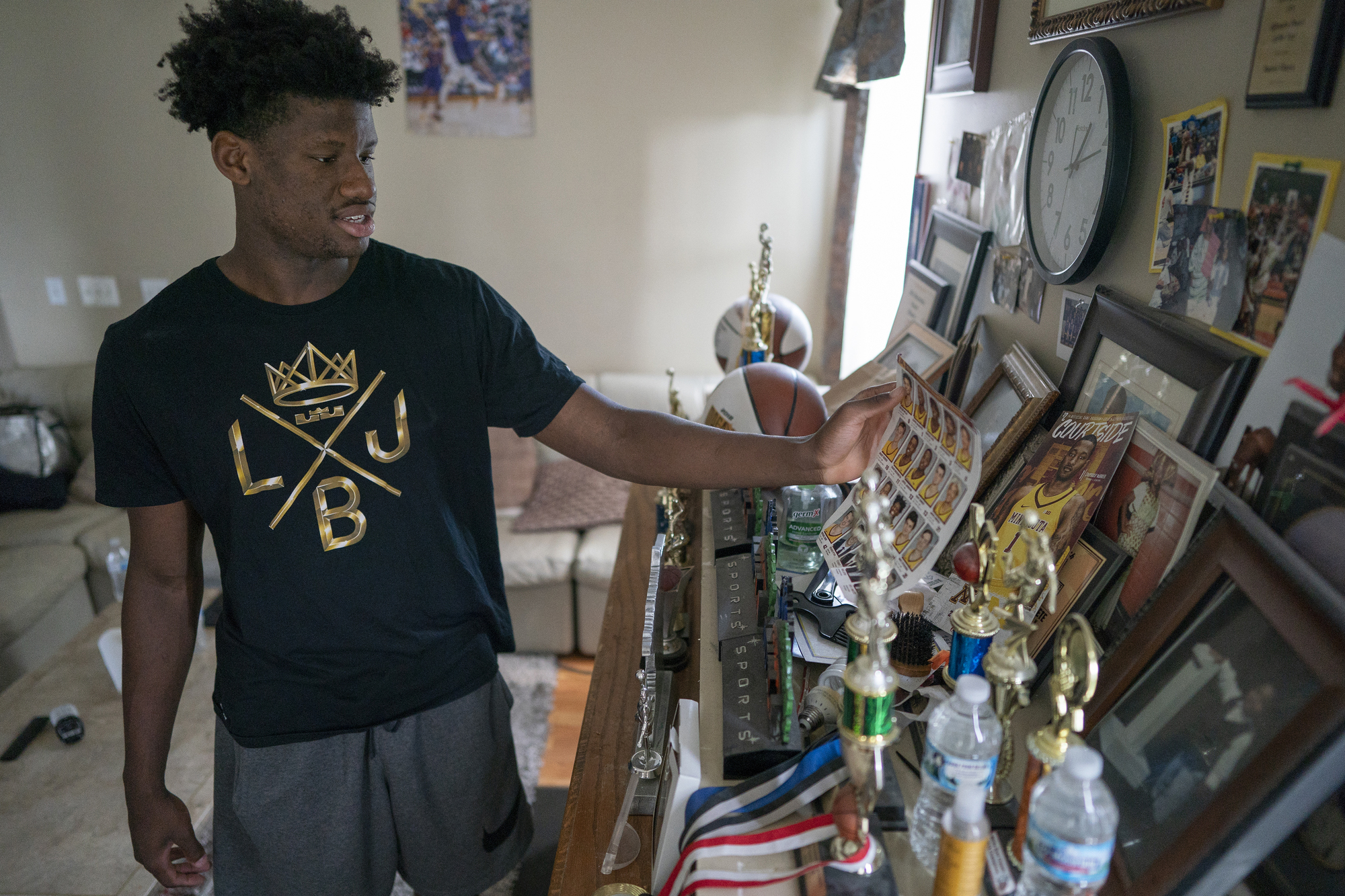 Daniel Oturu at his home in Woodbury looking at his many trophies and awards.