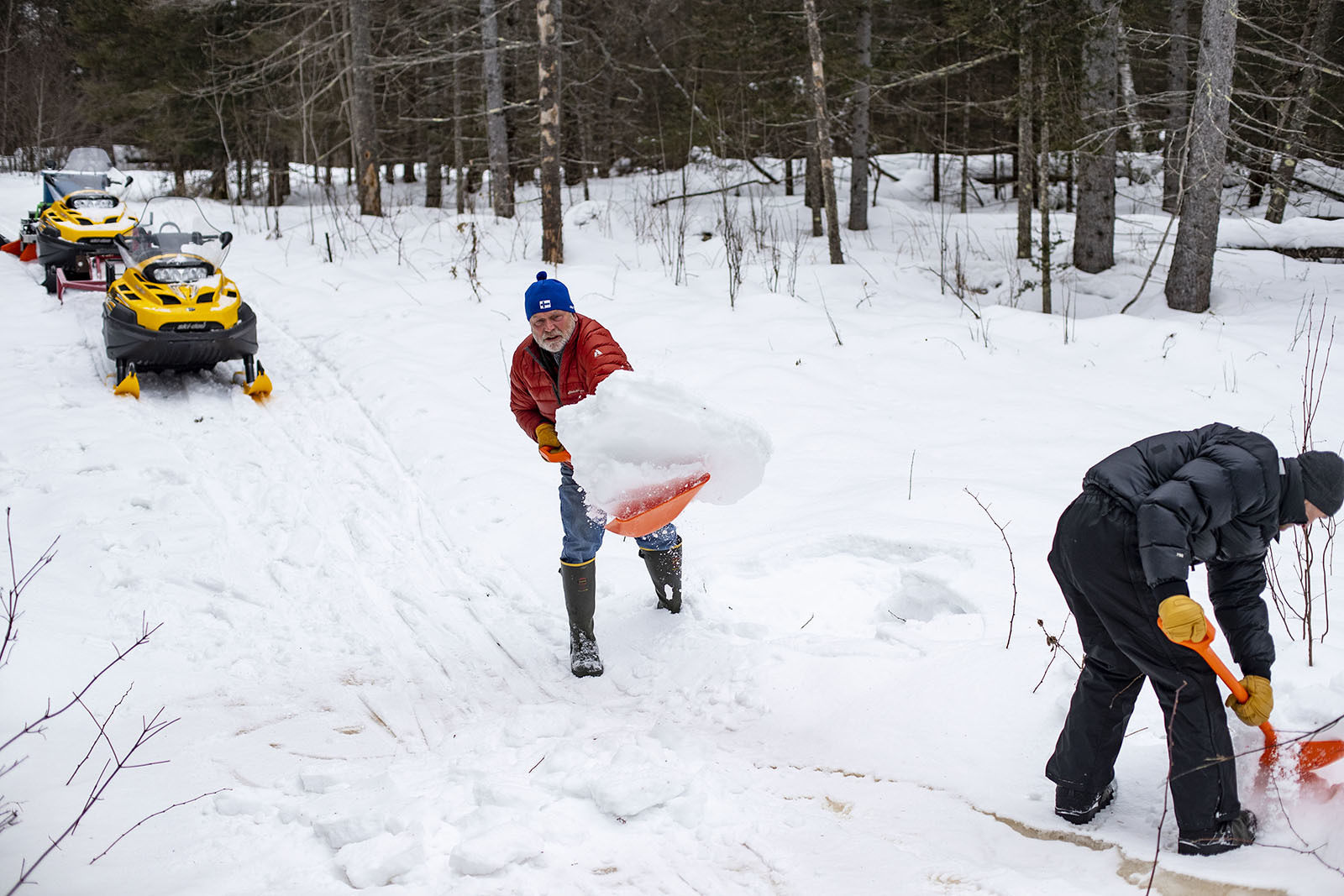 Helmer, left, and another groomer, Craig Brown, shoveled snow to reinforce an icy patch of the ski trail.