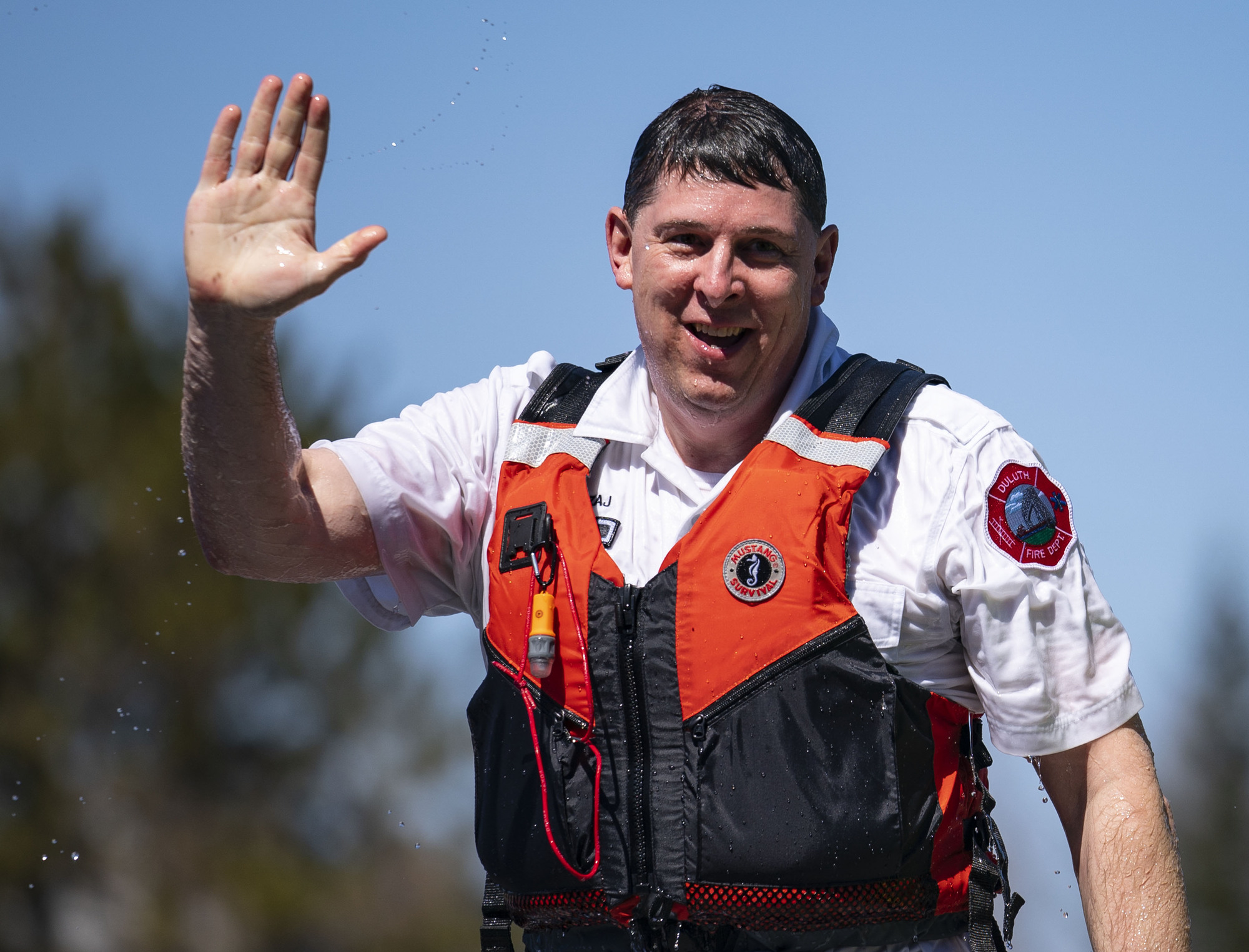 Fire Chief Shawn Krizaj waved to bystanders as he warmed up after jumping into Lake Superior.
