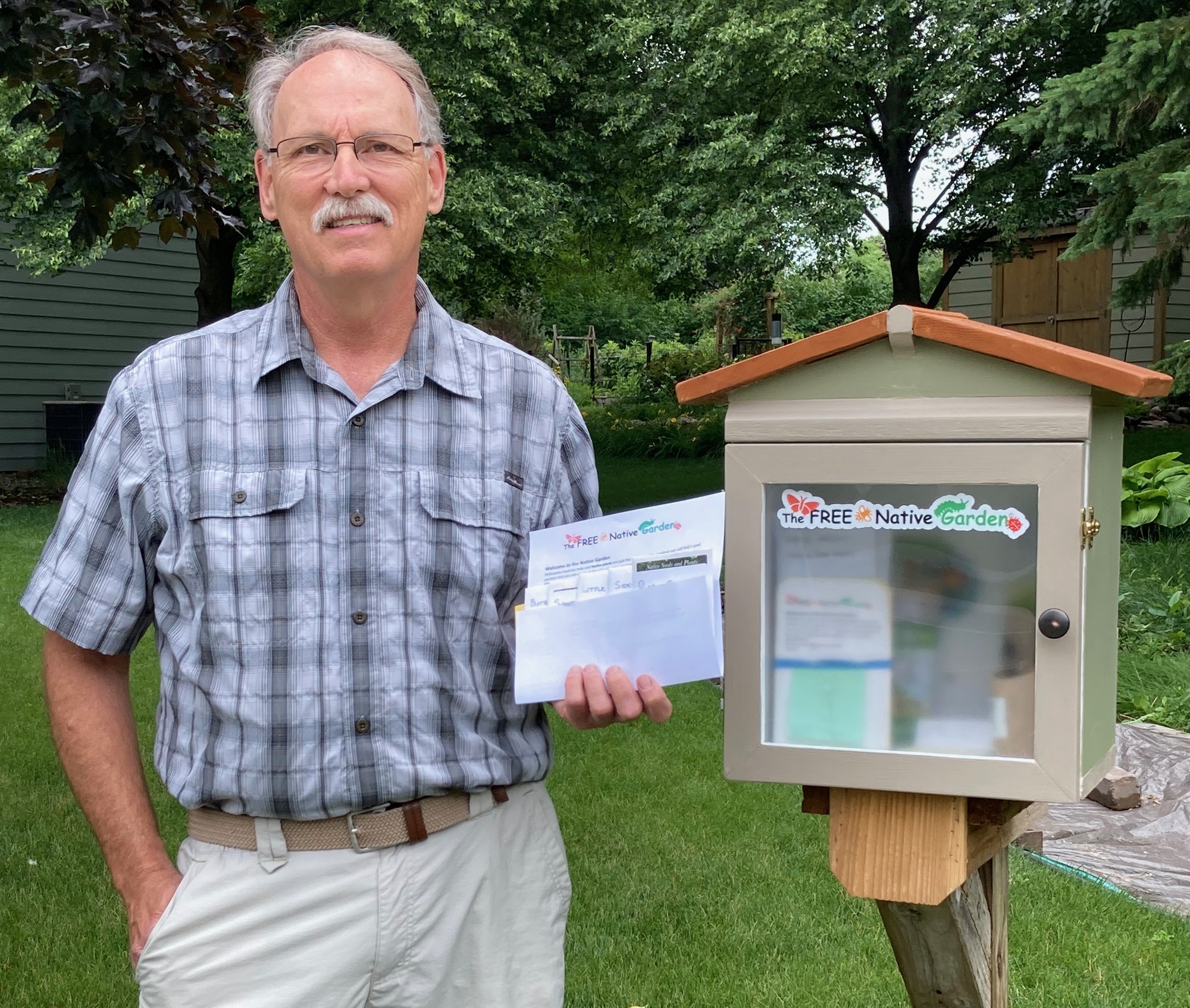 Jon Peschman stood by a Little Free Library that he constructed to give away seed packets of native plants.