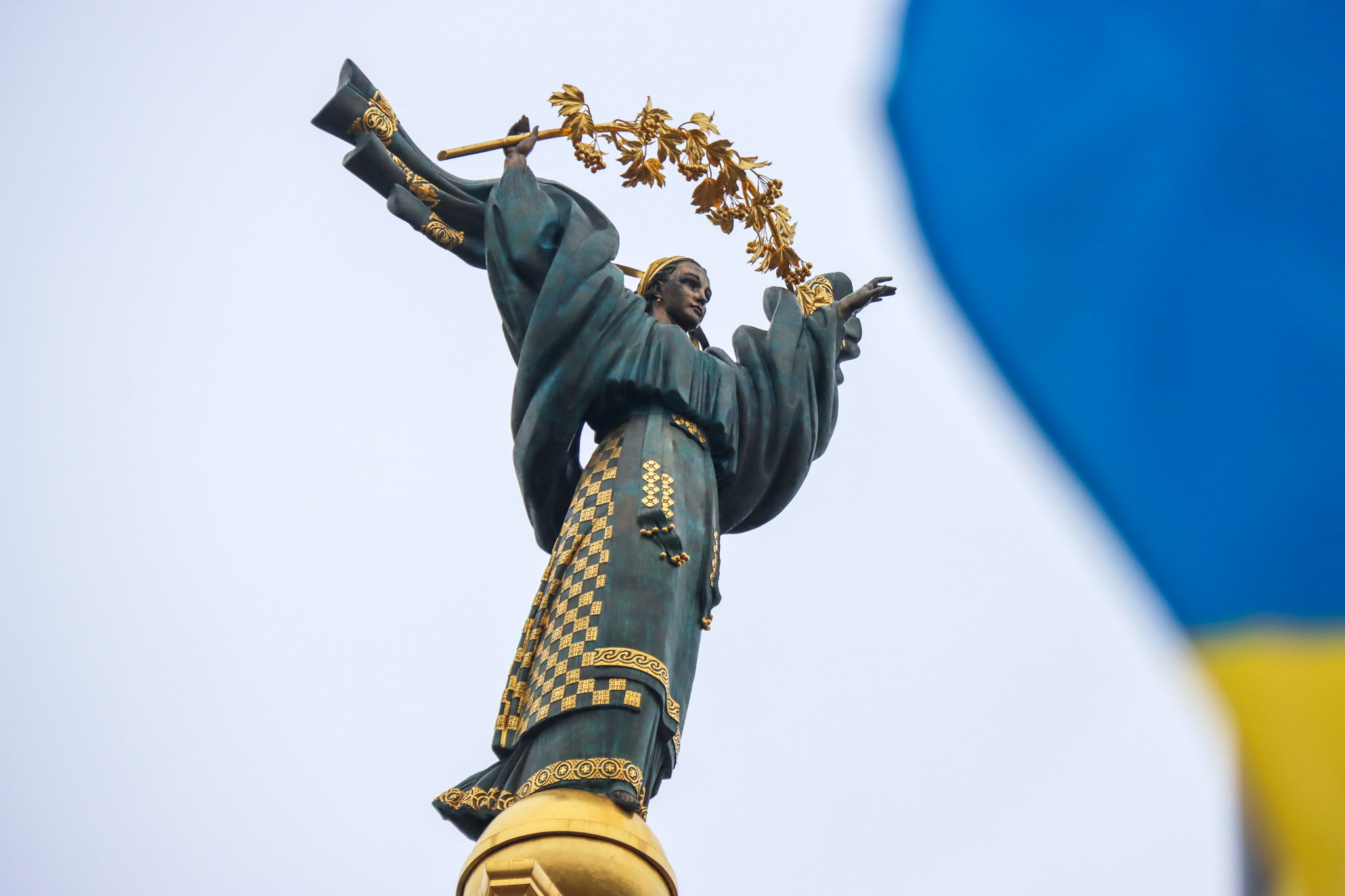 The Ukrainian flag in central Kyiv, with the Independence Square statue.