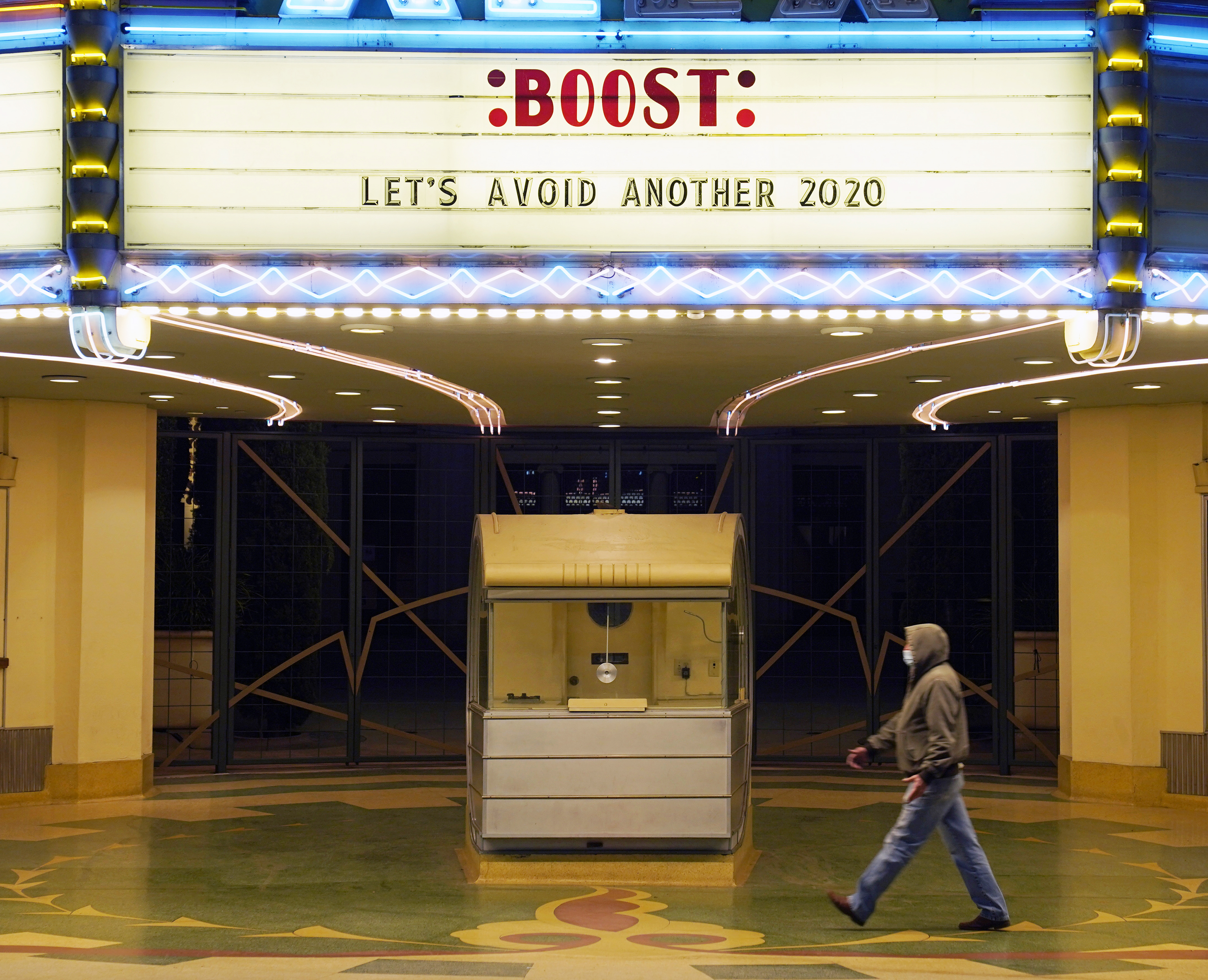 A theater marquee bears the message, “Boost: Let’s avoid another 2020.”