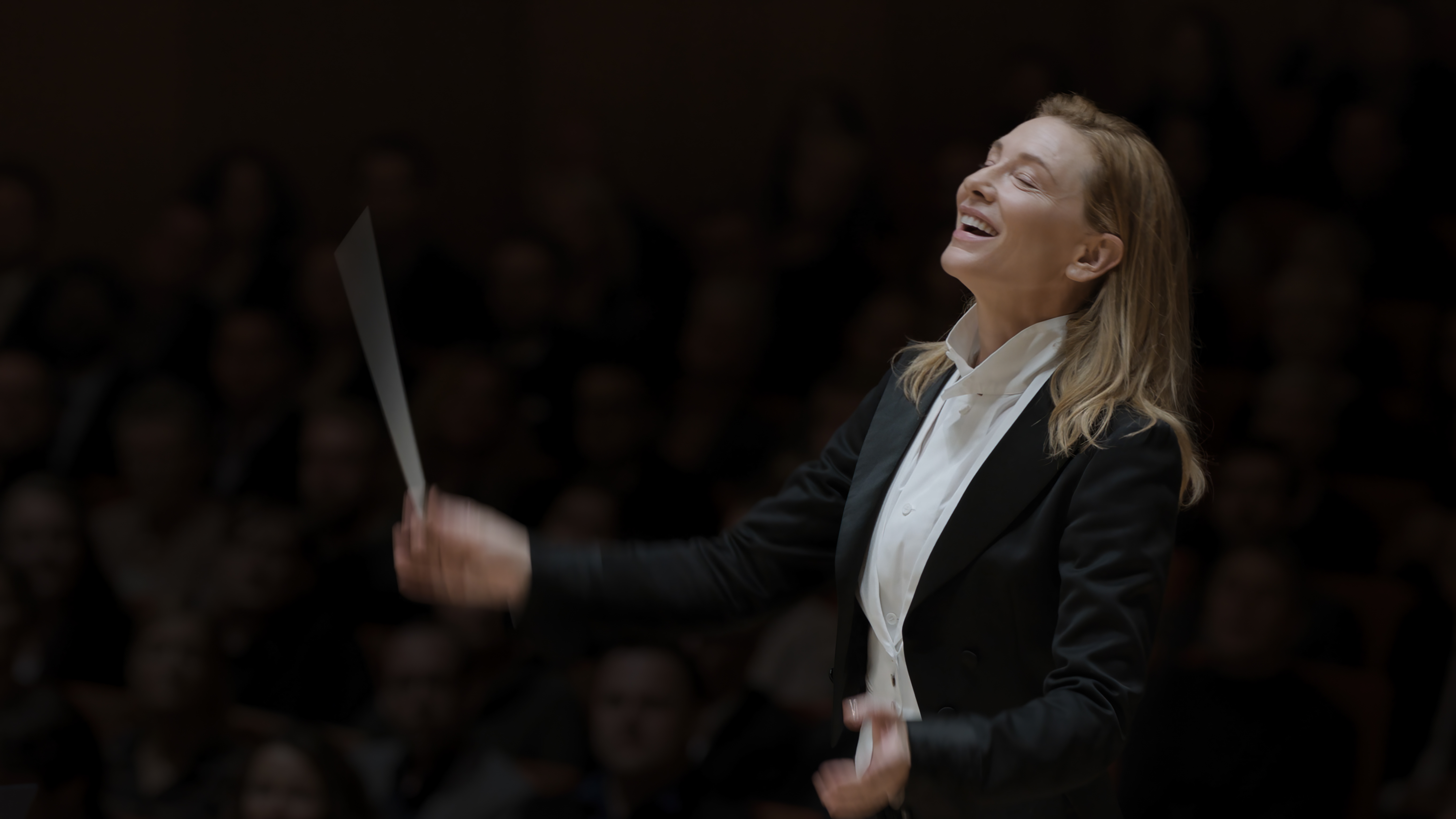 Cate Blanchett as an orchestra conductor, baton in hand.