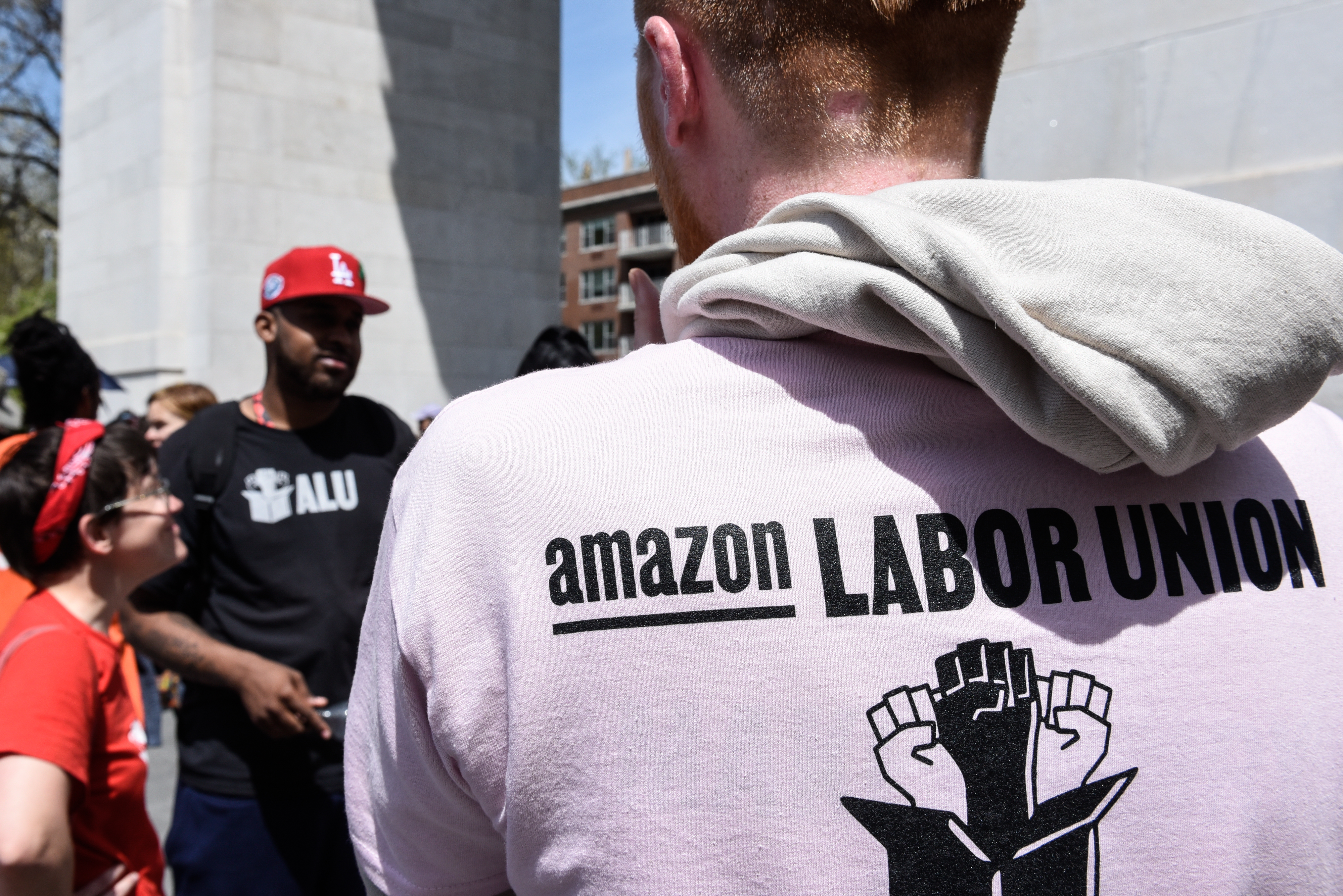 An Amazon worker wearing a hooded sweatshirt with “Amazon Labor Union” written on the back.