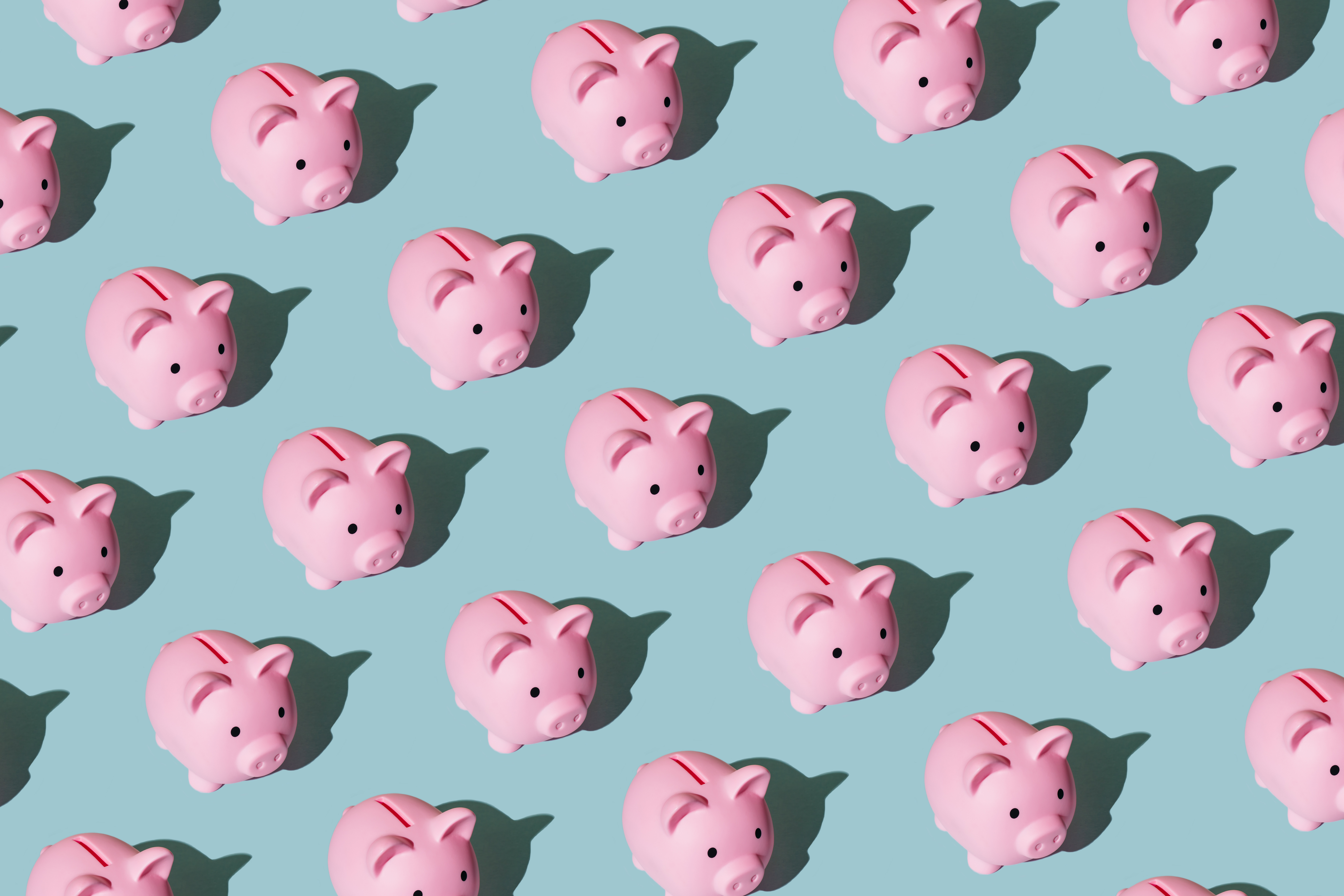 Pattern made of pink piggy banks on a blue background.