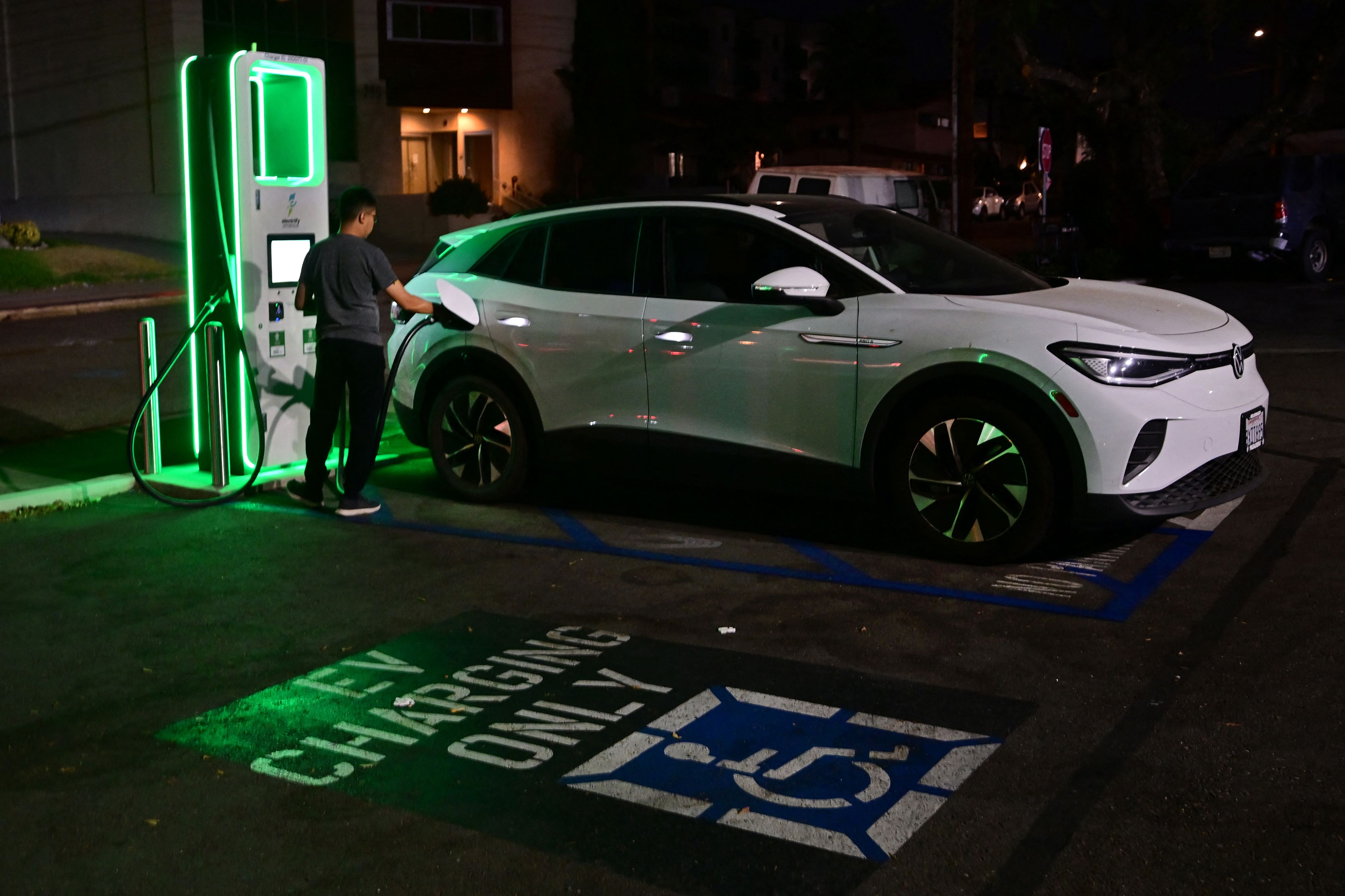 A driver charges his electric vehicle at a charging station as the California Independent System Operator announced a statewide electricity Flex Alert urging conservation to avoid blackouts in Monterey Park, California on August 31, 2022.