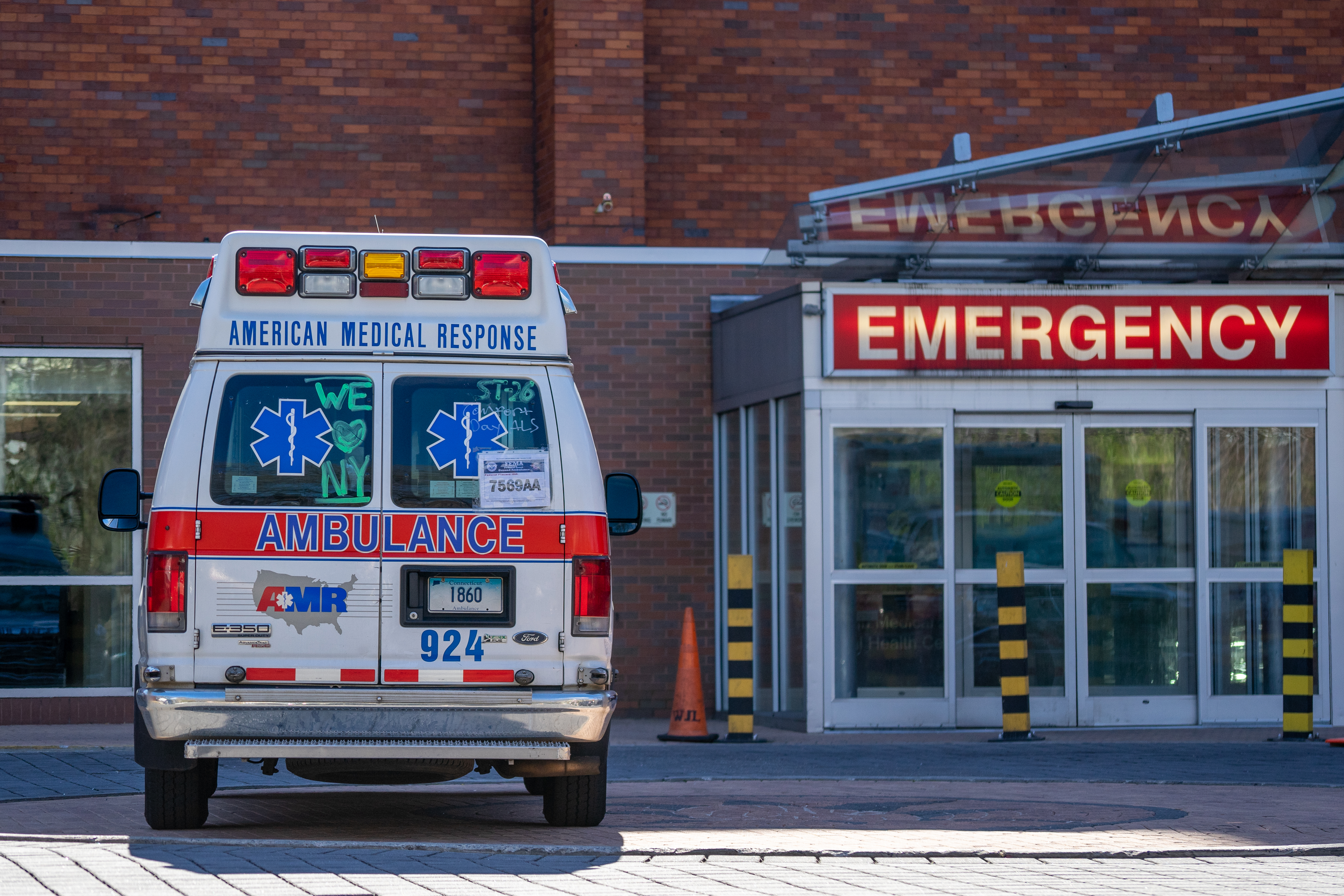 A photo of the exterior of an emergency room and an ambulance. 