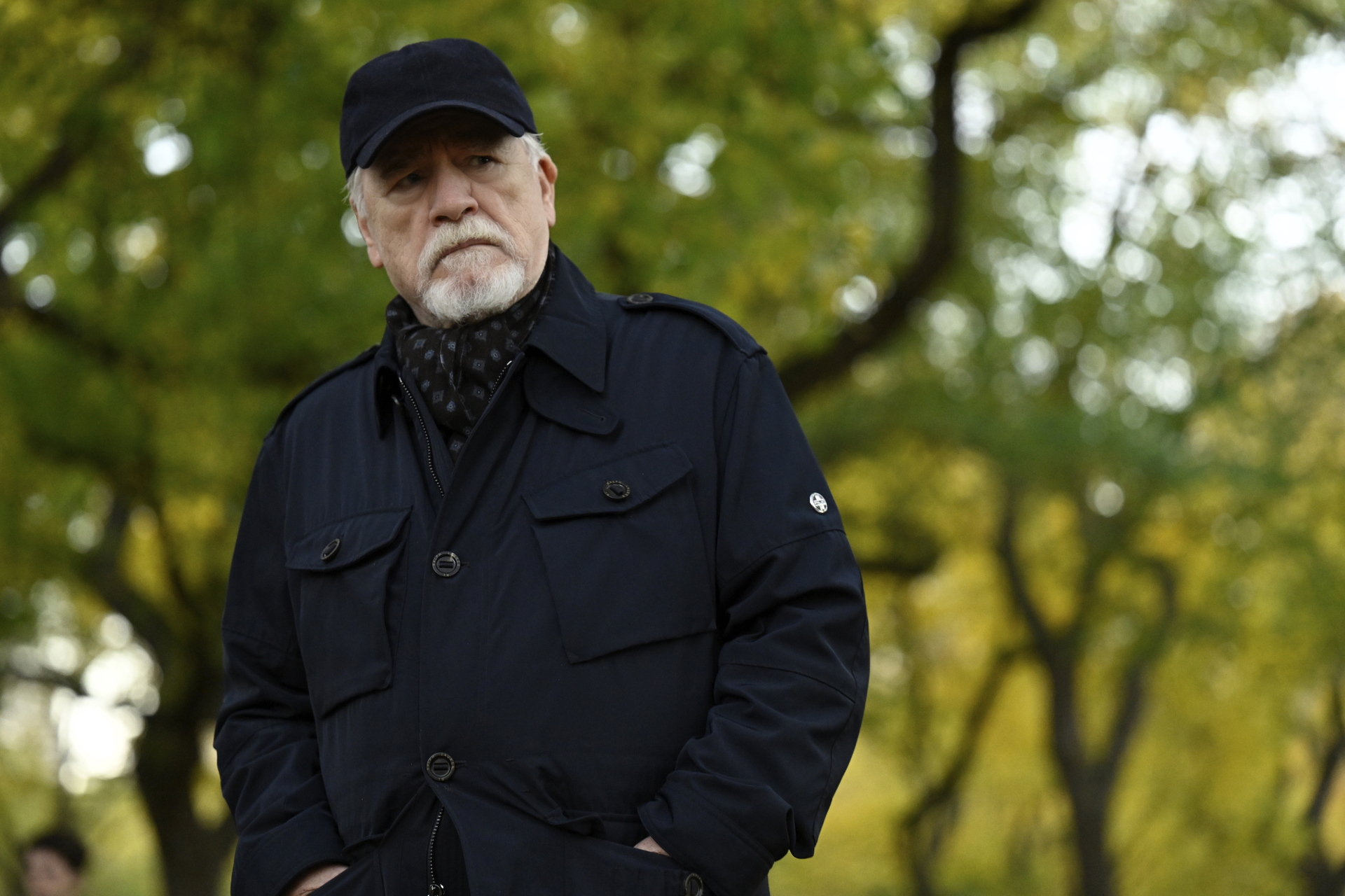 Brian Cox as Logan Roy in HBO’s Succession, wearing an all-black outfit with a black baseball cap and white beard.