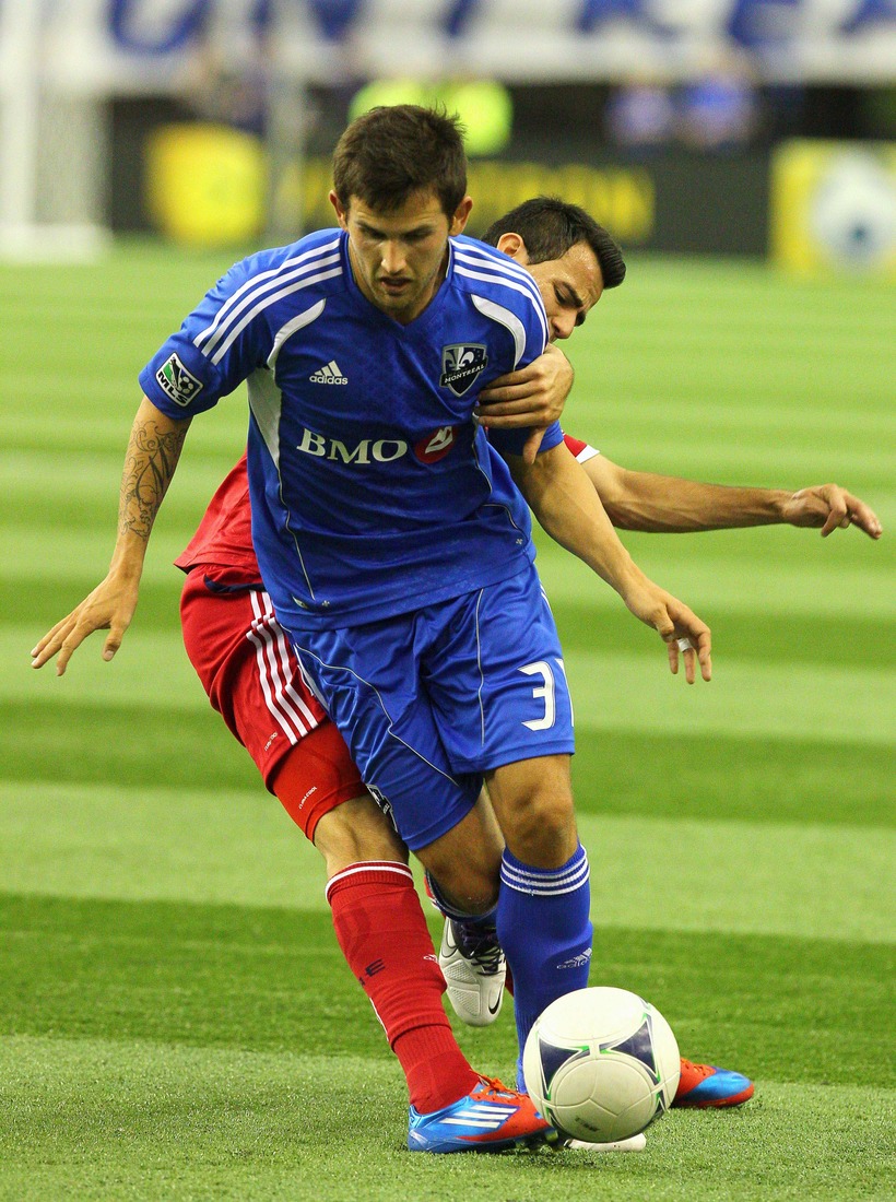 March 17, 2012; Montreal, QC, CAN; Chicago Fire forward Patrick Nyarko (14) and Montreal Impact defenseman Josh Gardner (31) battle for the ball during the first half at the Olympic Stadium. Mandatory Credit: Jean-Yves Ahern-US PRESSWIRE.