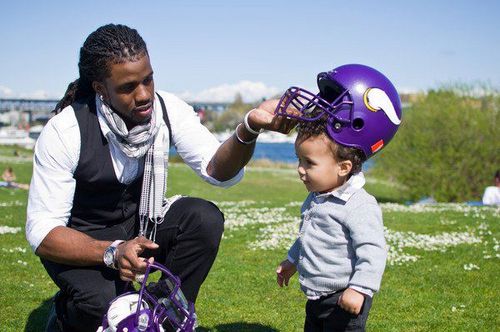 This is the only non-copyrighted picture I could find that has him with Vikings gear, and it's one hell of a picture. That's his son, Dash, learning all that is good and holy.