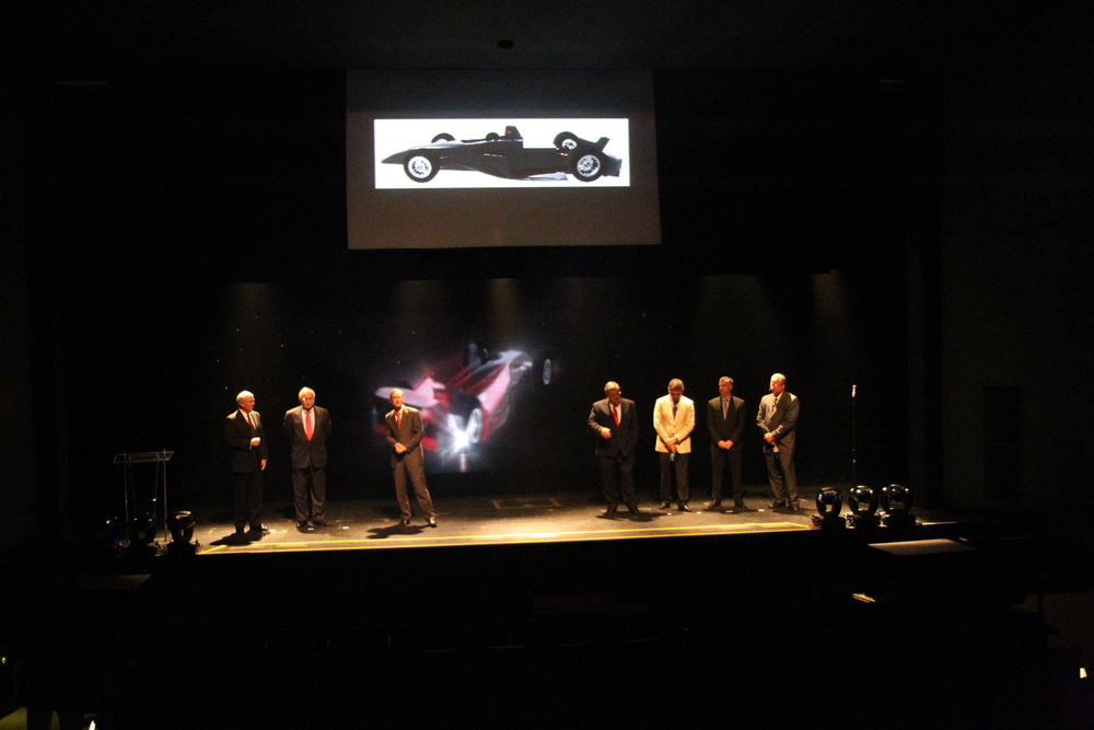 The members of the IZOD IndyCar Series ICONIC advisory committee take the stage to announce the 2012 IndyCar chassis strategy. The Dallara-built "Safety Cell" common tub is displayed in the background. (Photo: Ron McQueeney/IMS Photo)