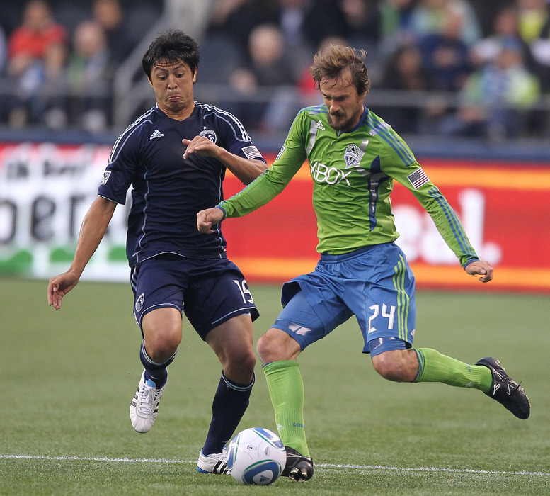 SEATTLE - MAY 21: Roger Levesque #24 of the Seattle Sounders FC battles Roger Espinoza #15 of Sporting Kansas City at Qwest Field on May 21, 2011 in Seattle, Washington. (Photo by Otto Greule Jr/Getty Images)
