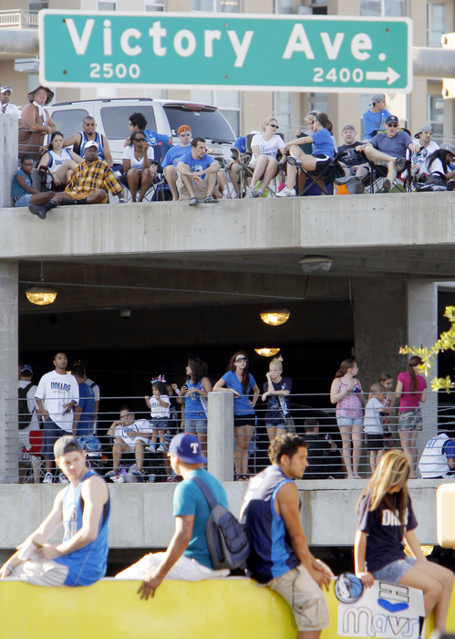 DALLAS, TX - JUNE 16: Dallas Mavericks fans sit on top of a parking garage and a fence while waiting for the Dallas Mavericks Victory Parade on June 16, 2011 in Dallas, Texas. (Photo by Brandon Wade/Getty Images)