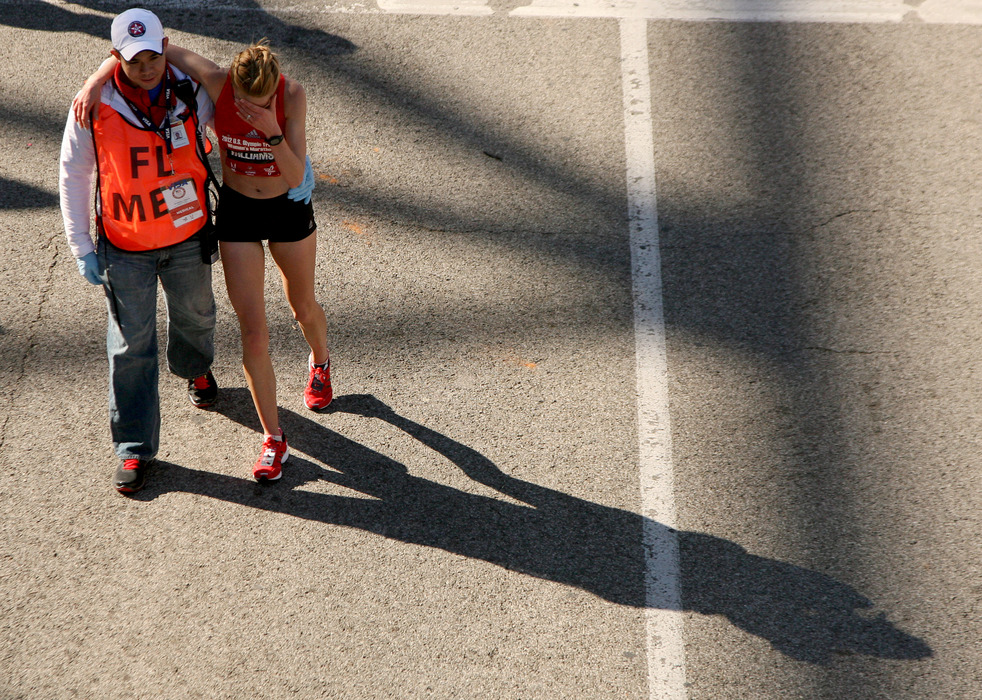HOUSTON, TX - JANUARY 14: A runner is assisted as she holds her head after finishing in the U.S. Marathon Olympic Trials January 14, 2012 in Houston, Texas. (Photo by Thomas B. Shea/Getty Images)