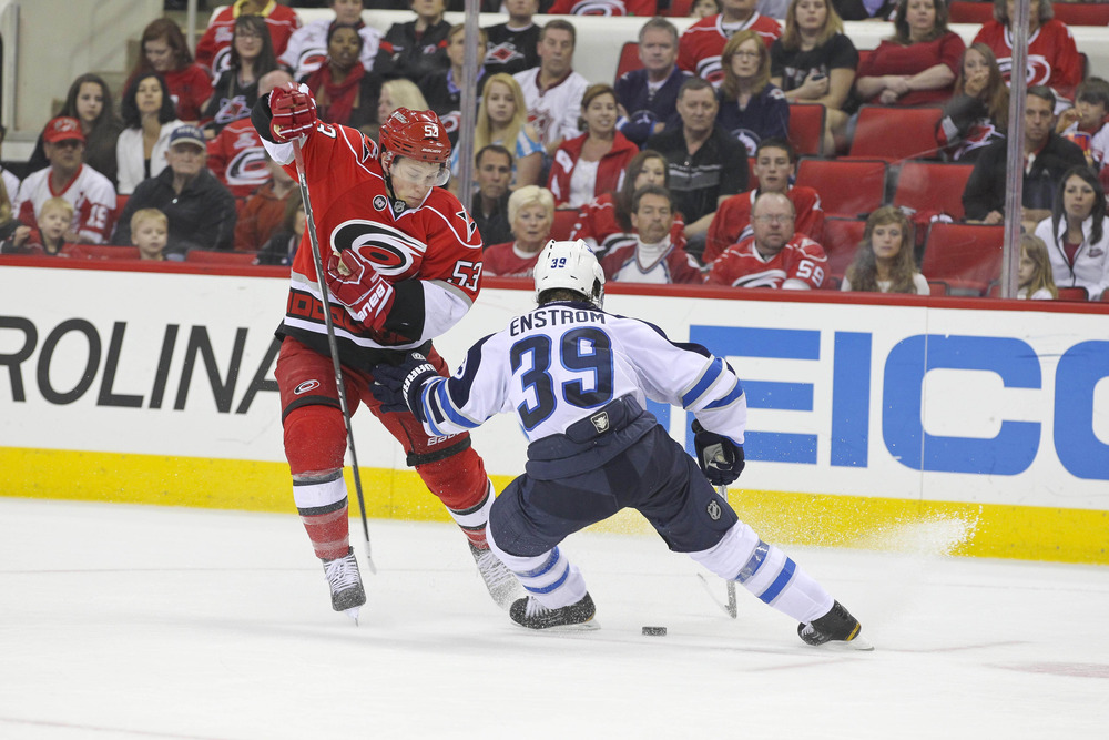March 30, 2012; Raleigh, NC, USA; Carolina Hurricanes center Jeff Skinner (53) tries to carry the puck by the Winnipeg Jets defensemen Tobias Enstrom (39) during the 2nd period at the PNC center. Mandatory Credit: James Guillory-US PRESSWIRE