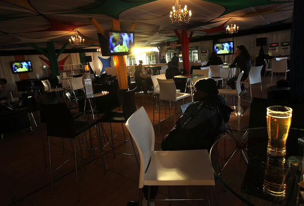 JOHANNESBURG, SOUTH AFRICA:  A Cameroon soccer fan sits in an almost empty restaurant while watching a soccer match between Cameroon and Japan. (Photo by John Moore/Getty Images)