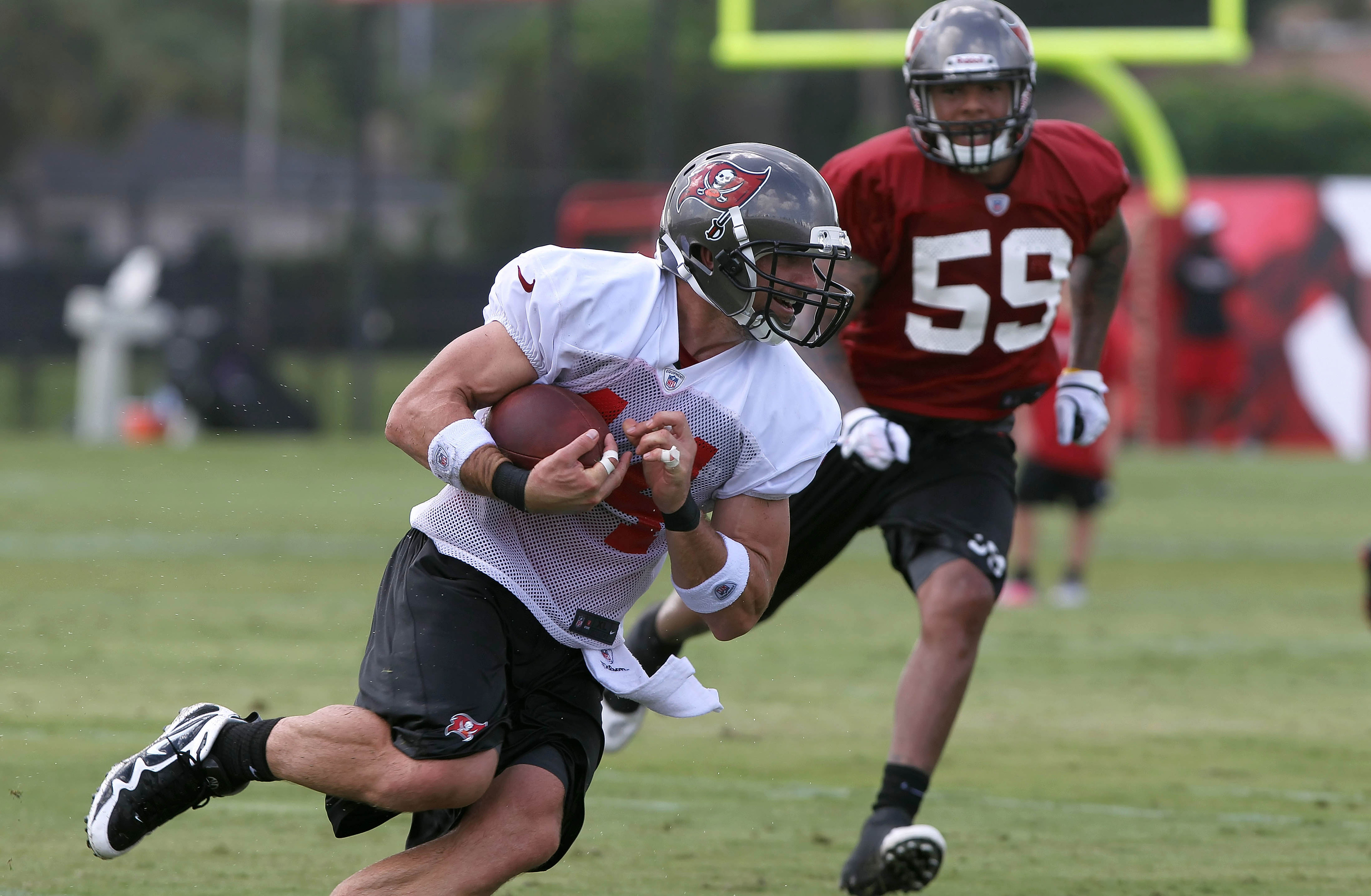July 28, 2012; Tampa, FL, USA;  Tampa Bay Buccaneers tight end Dallas Clark (44) catches the ball and runs as linebacker Mason Foster (59) defends during training camp at One Buc Place. Mandatory Credit: Kim Klement-US PRESSWIRE