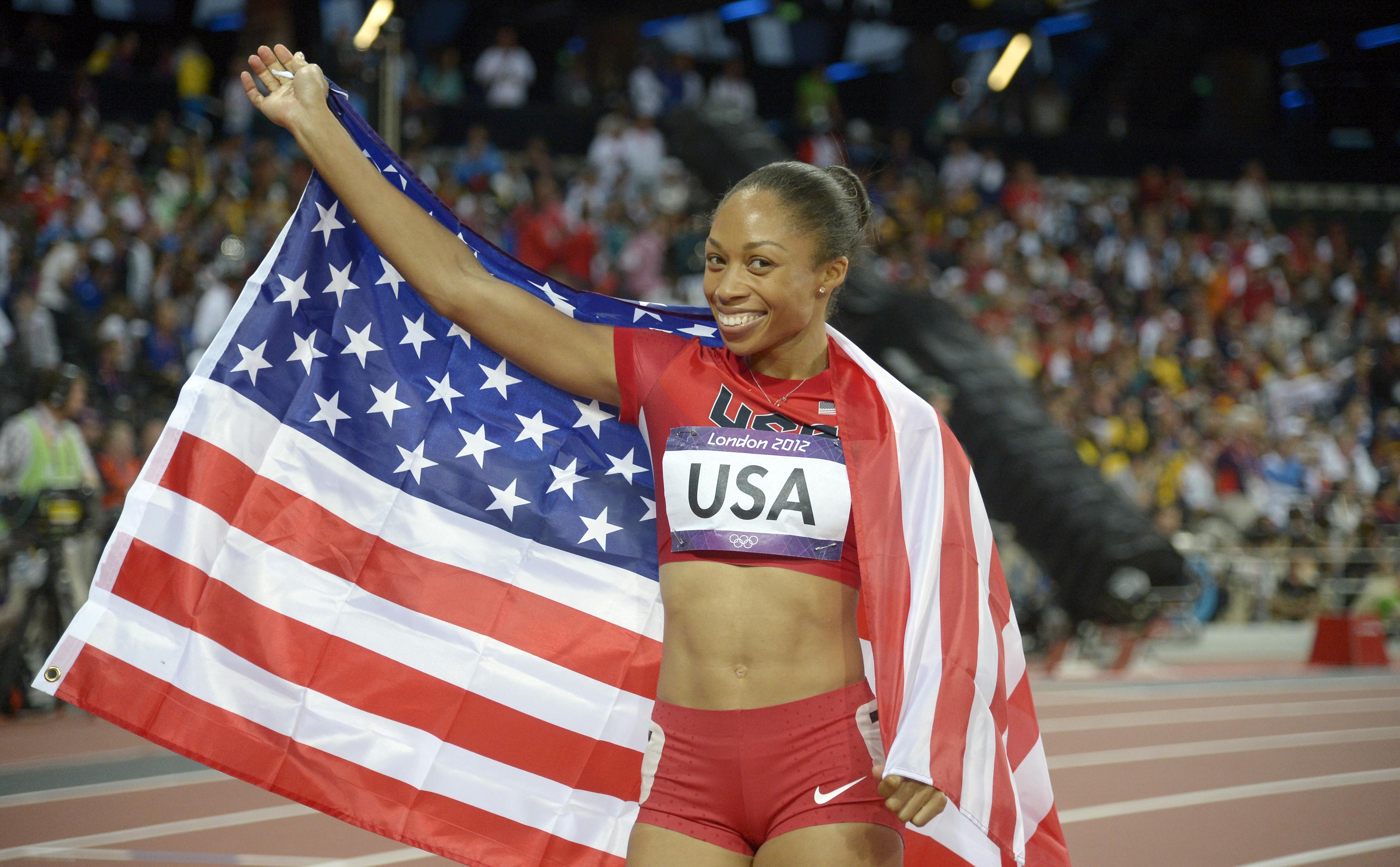 Aug 11, 2012; London, United Kingdom; Allyson Felix (USA) celebrates with an American flag after winning the women's 4x400m relay final during the 2012 London Olympic Games at Olympic Stadium. Mandatory Credit: Kirby Lee-USA TODAY Sports