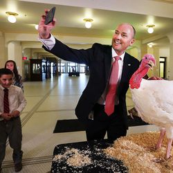 Lt. Gov. Spencer Cox takes a photo with Sir Featherbottoms, a turkey he pardoned at the Capitol in Salt Lake City on Monday, Nov. 21, 2016.