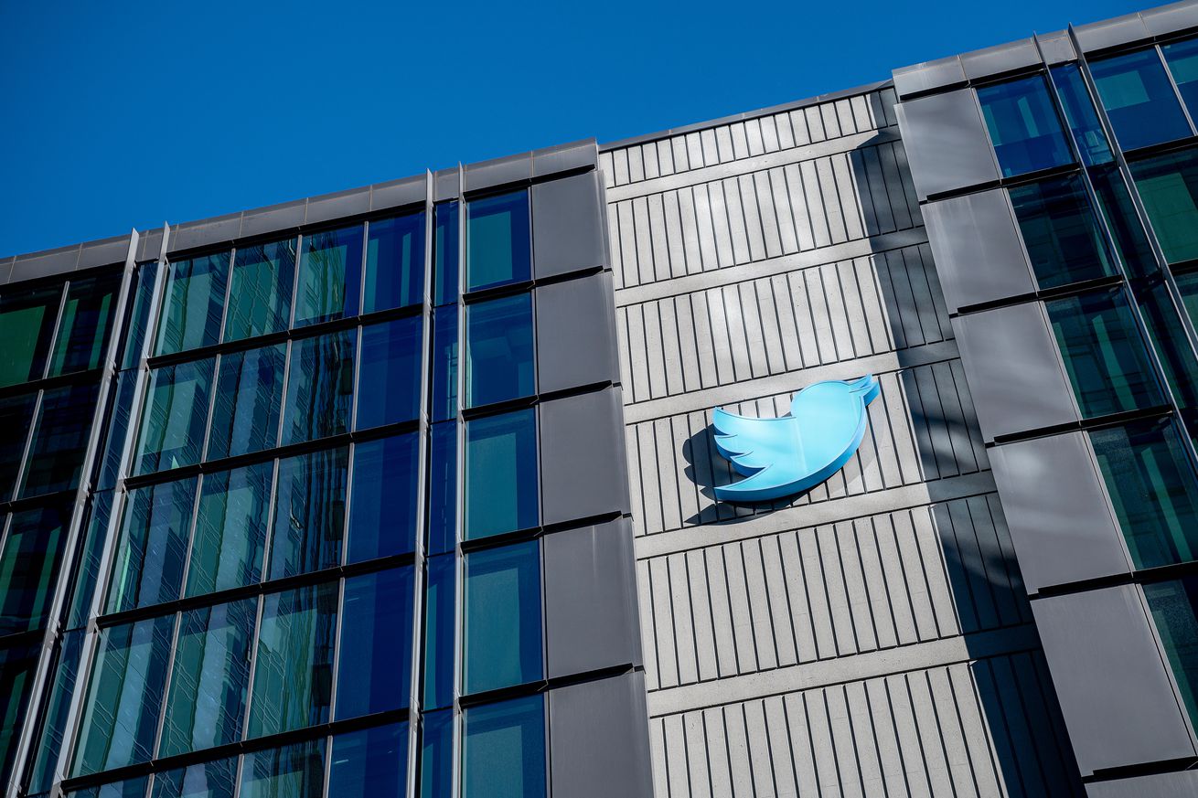 The front of an office building with a Twitter logo on the front.