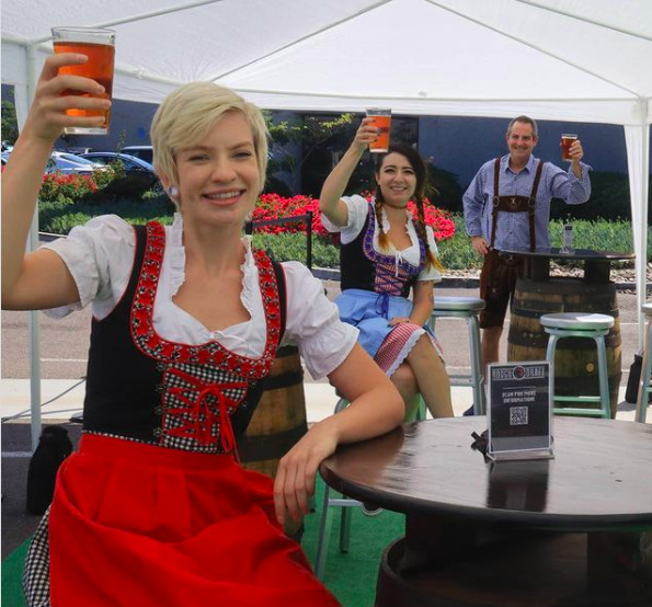 People in Oktoberfest outfits holding beer.