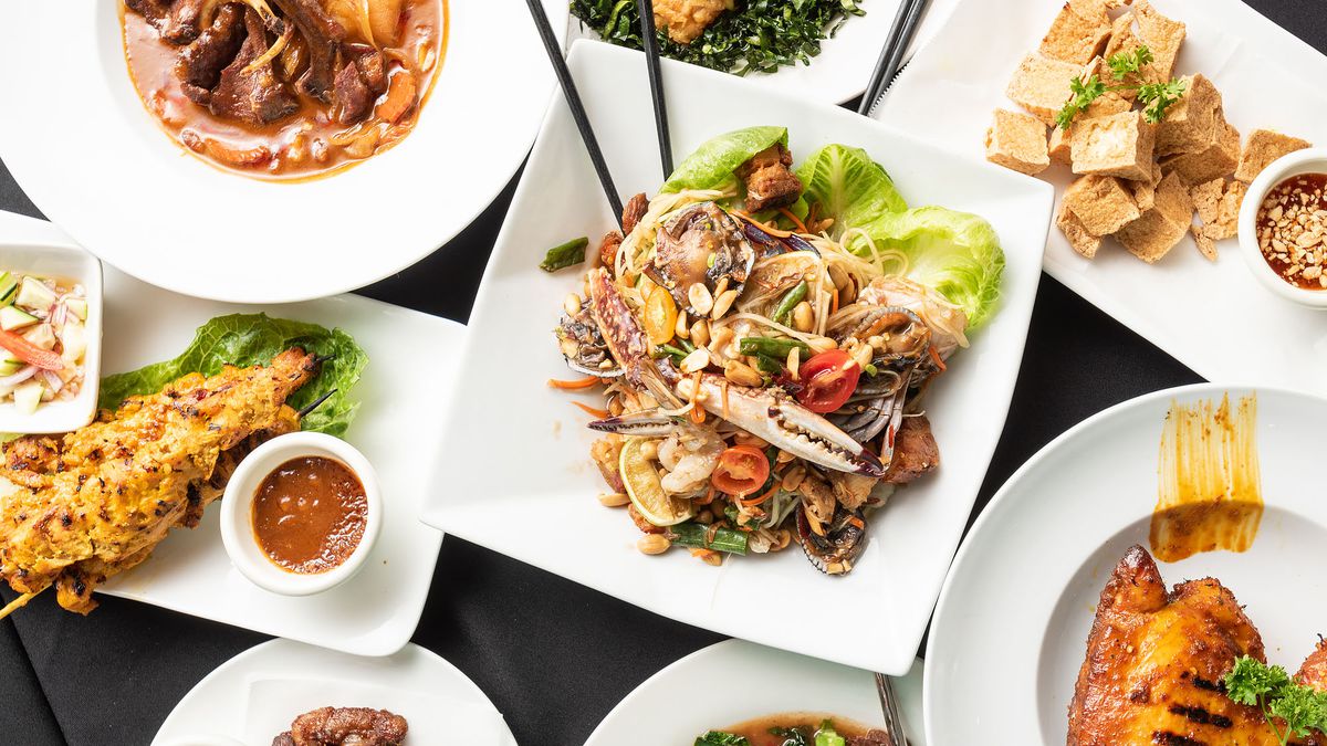Numerous plates full of food, like pad Thai, fried fish, and tofu. 