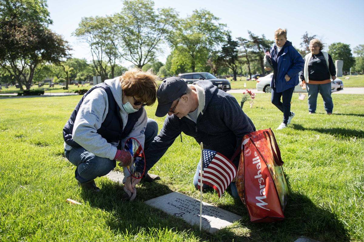 Deb Frost Baker and Jerry Frost, who are relatives of Col. Helen L. McCormick, place a pinwheel Saturday on her grave at St. Mary Catholic Cemetery and Mausoleums in Evergreen Park. McCormick was a member of the Army Nurse Corps who saw service in World War II in Europe and during the Korean war and the Vietnam war.