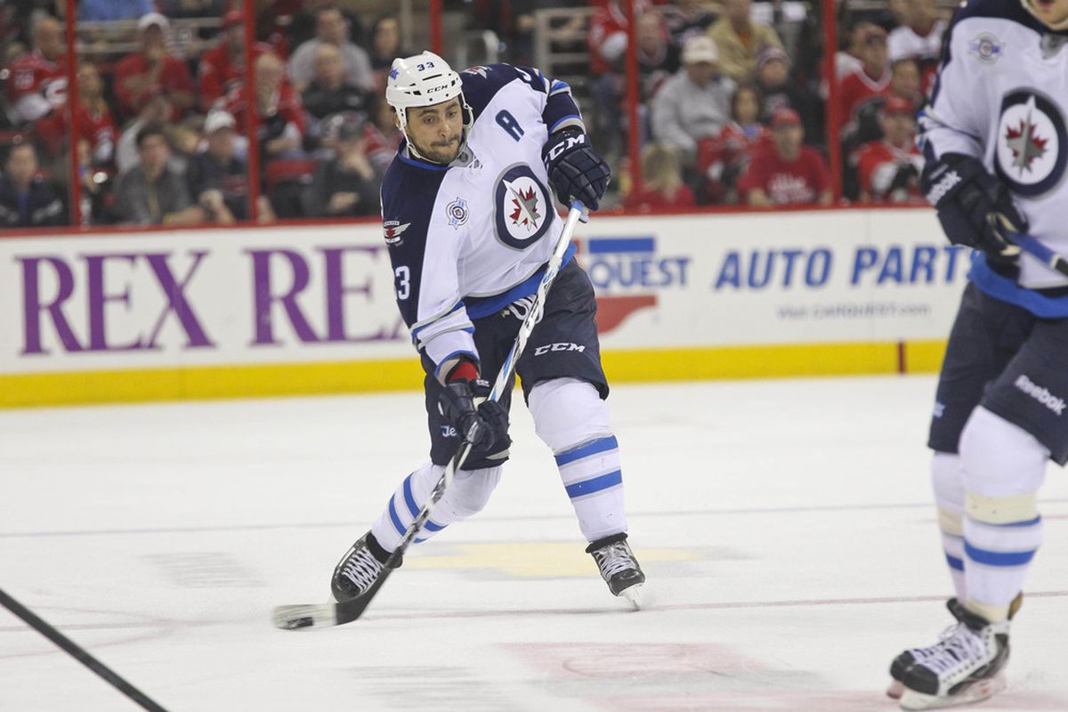 March 30, 2012; Raleigh, NC, USA; Winnipeg Jets defensemen Dustin Byfuglien (33) takes a slap shot against the Carolina Hurricanes at the PNC center. The Jets defeated the Hurricanes 4-3 in overtime. Mandatory Credit: James Guillory-US PRESSWIRE