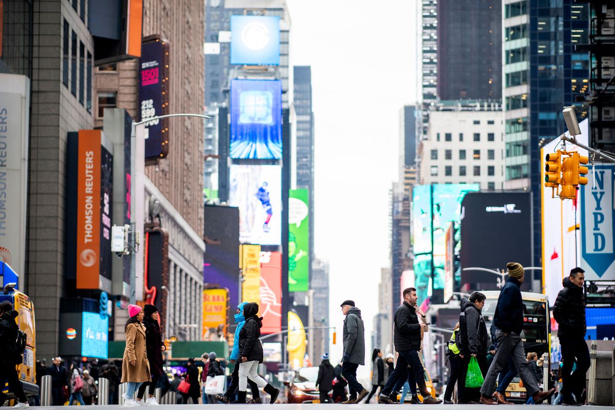 People walk across 42nd street at Time Square in Manhattan on January 14, 2020 in New York City