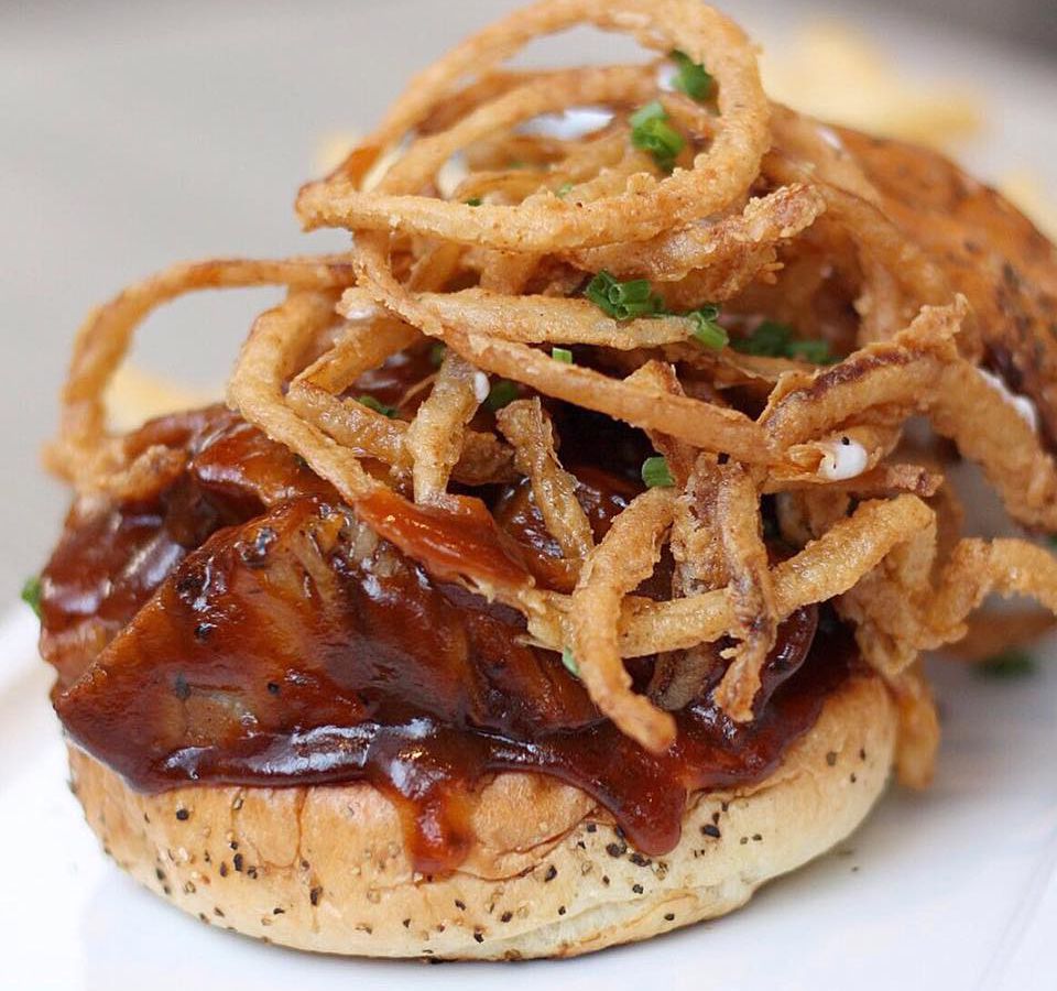 Open faced brisket sandwich topped with fried onions.