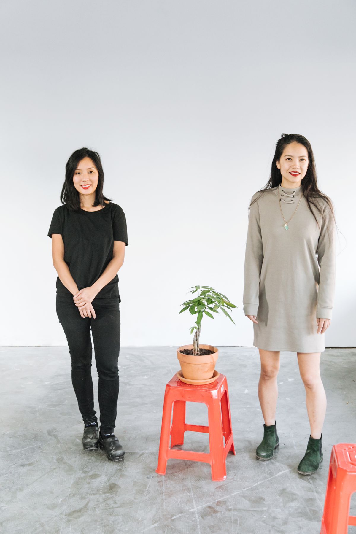 Valerie Luu (left) and Katie Kwan, with a potted plant on top of a red stool