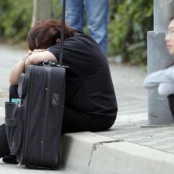 A Santa Monica College student waits for police clearance to pick up her vehicle after a shooting on campus Friday June 7, 2013 in Santa Monica, Calif. A gunman with an assault-style rifle killed at least six people in Santa Monica on Friday before police shot him to death in a gunfight in the Santa Monica College library.