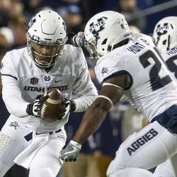 Utah State quarterback Kent Myers (2) hands the ball off to running back LaJuan Hunt (21) during an NCAA college football game against Brigham Young in Provo on Saturday, Nov. 26, 2016.