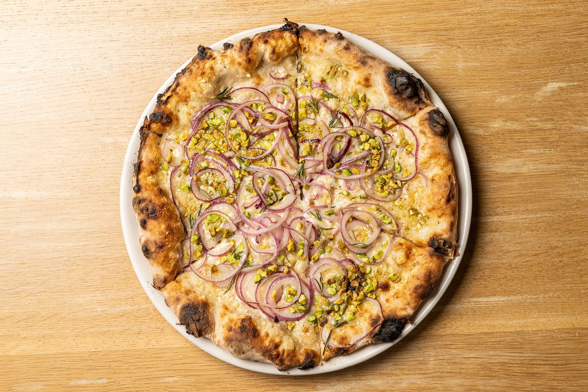 A pizza topped with pistachios and red onion at Pizzeria Bianco.
