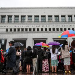 Conferencegoers wait in the rain to get into the afternoon session of the LDS Church’s 187th Annual General Conference at the Conference Center in Salt Lake City on Sunday, April 2, 2017.