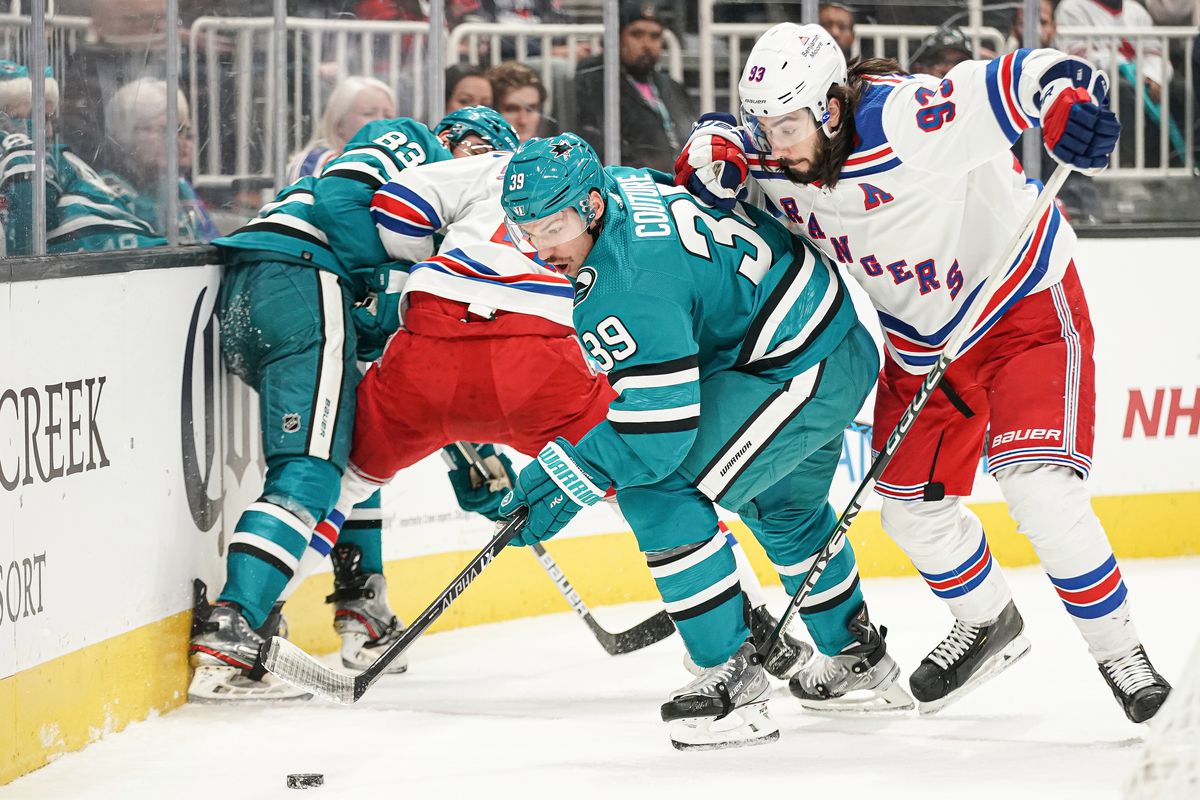Logan Couture #39 of the San Jose Sharks battles for the puck against Mika Zibanejad #93 of the New York Rangers at SAP Center on November 19, 2022 in San Jose, California.