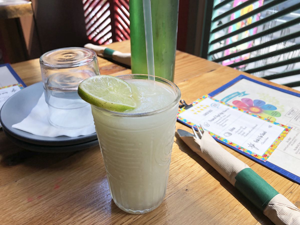 A frozen margarita at Vida Verde sits on a table next to a window