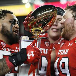 Utah Utes offensive lineman Isaac Asiata (54) and Utah Utes defensive end Hunter Dimick (49) hold the trophy after the Utes defeat the Indiana Hoosiers in the Foster Farms Bowl in Santa Clara, California, on Wednesday, Dec. 28, 2016.