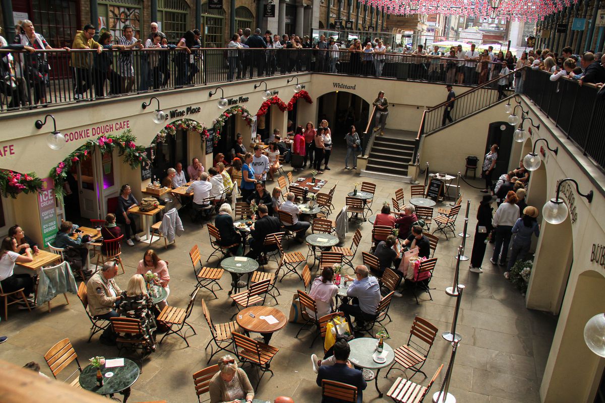 People enjoy meals under the hanging Union Jack flags at the Covent Garden market.