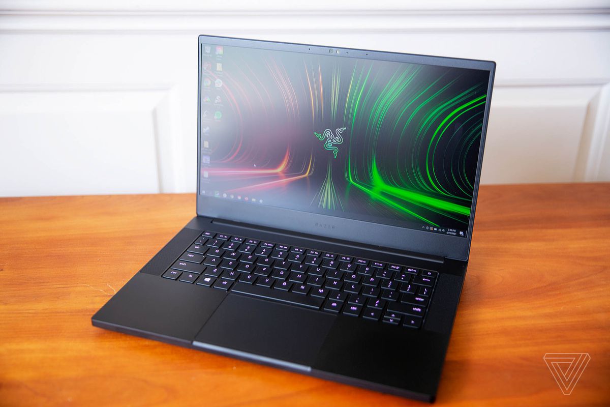 The Razer Blade 14 seen from above, open, angled to the left. The screen displays the Razer logo on a red and green background. The keys are lit a dark pink.