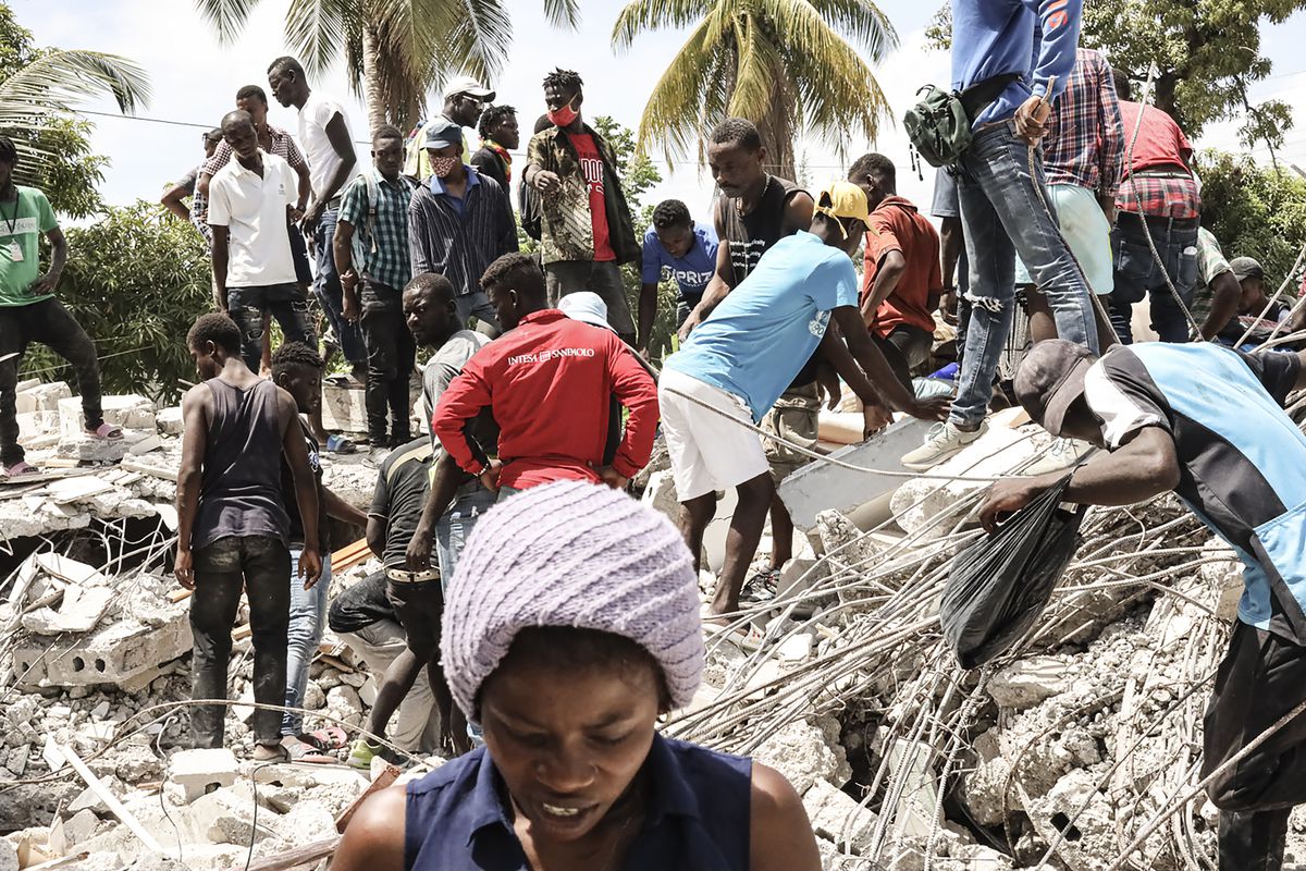 Residents search through the rubble of a collapsed hotel in Les Cayes, Haiti, on August 16, 2021.  Jonathan Alpeyrie/Bloomberg via Getty Images