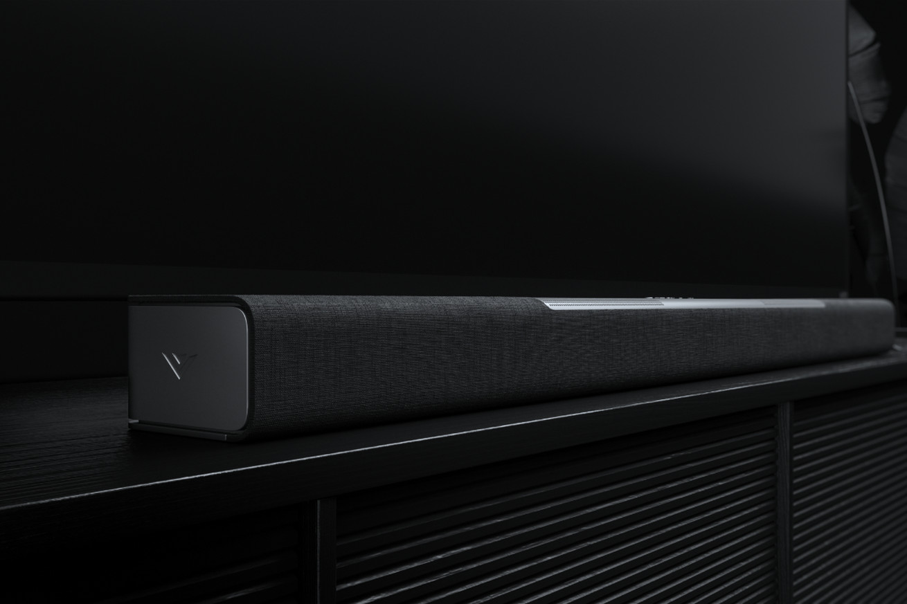 Vizio’s black M512a-H6 soundbar sitting on a TV stand against a black background.