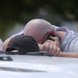 Elizabeth Shelley's great-grandfather by marriage puts his head on his arm as he makes a phone call while police search for the 5-year-old in the backyards of nearby homes in Logan on Wednesday, May 29, 2019.