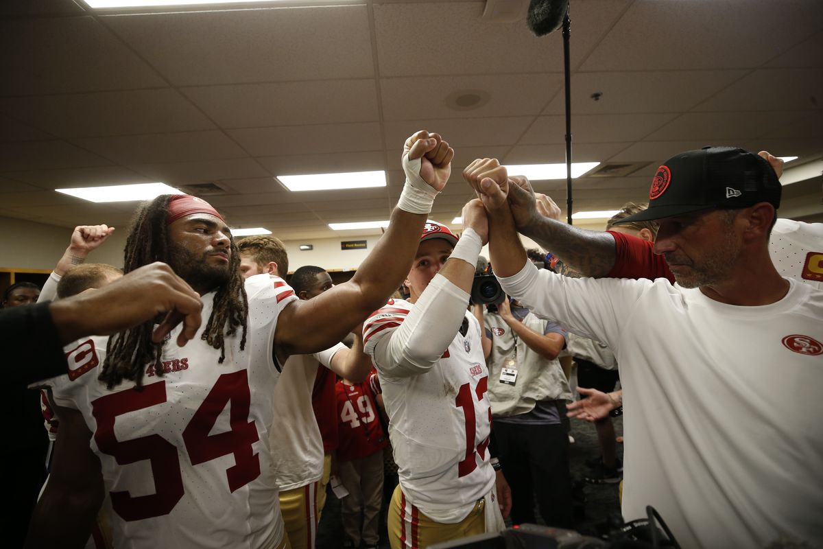 Fred Warner #54, Brock Purdy #13 and Head Coach Kyle Shanahan of the San Francisco 49ers in the locker room after the game against the Pittsburgh Steelers at Acrisure Stadium on September 10, 2023 in Pittsburgh, Pennsylvania.