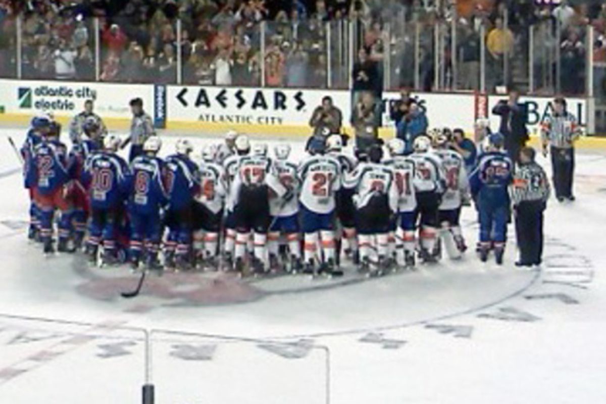 Team New York and Team Philadelphia congregate at center ice for a group photo after their charity game.