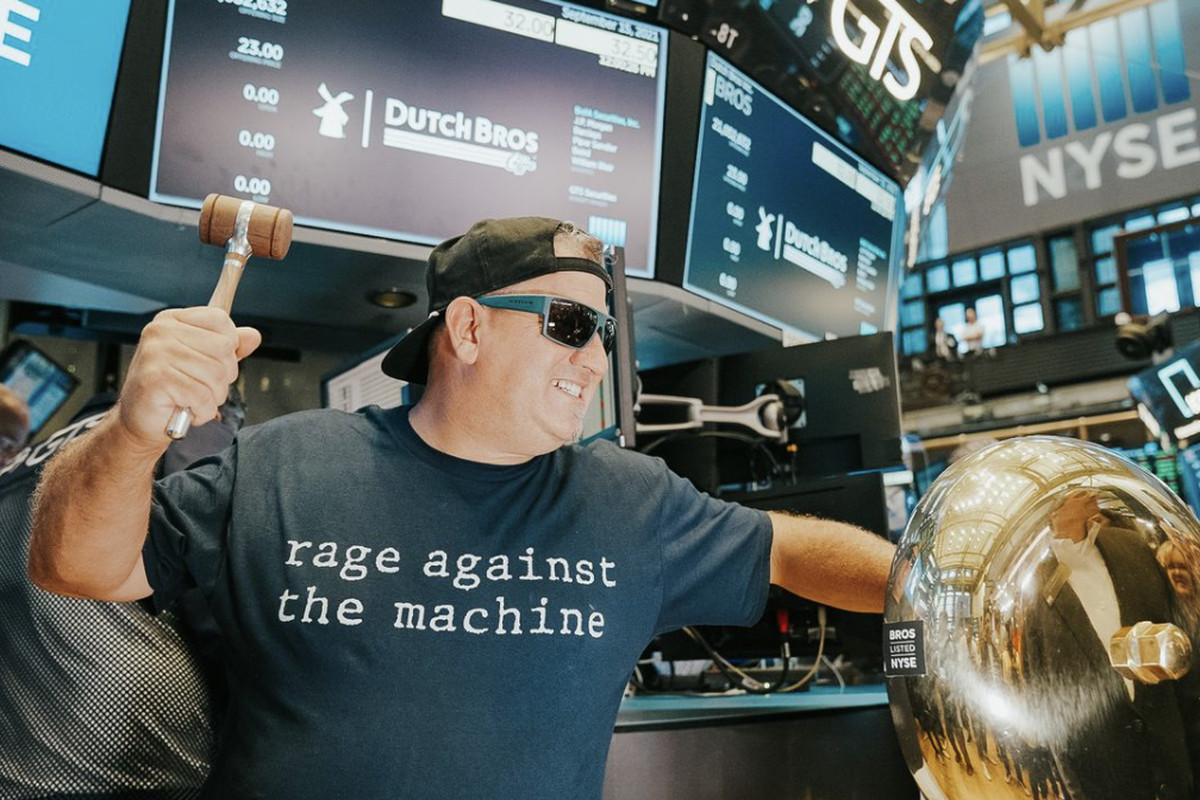 A man in a backwards baseball cap rings the trade bell on the floor of the New York Stock Exchange.